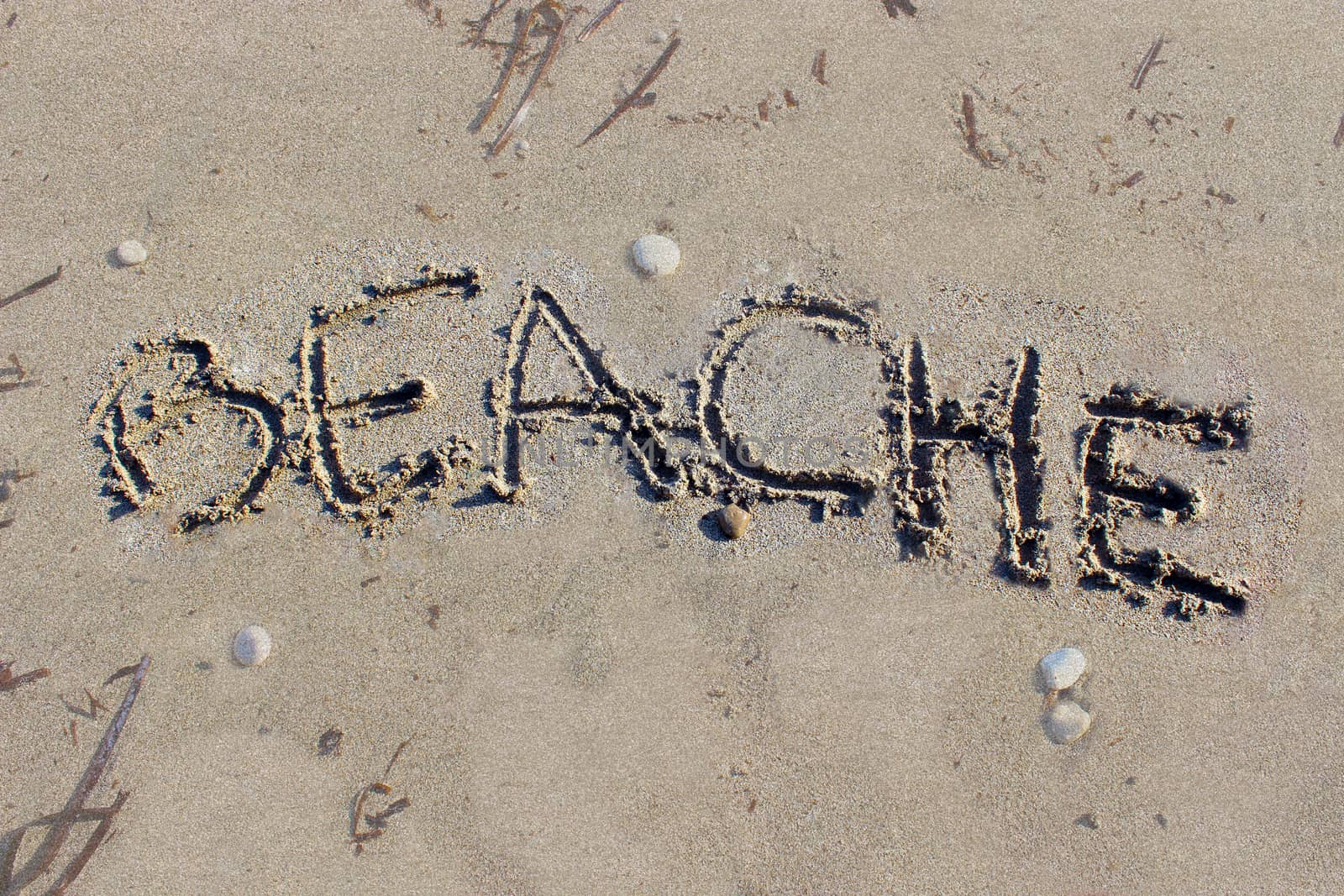 "Beach" written in the sand on the beach