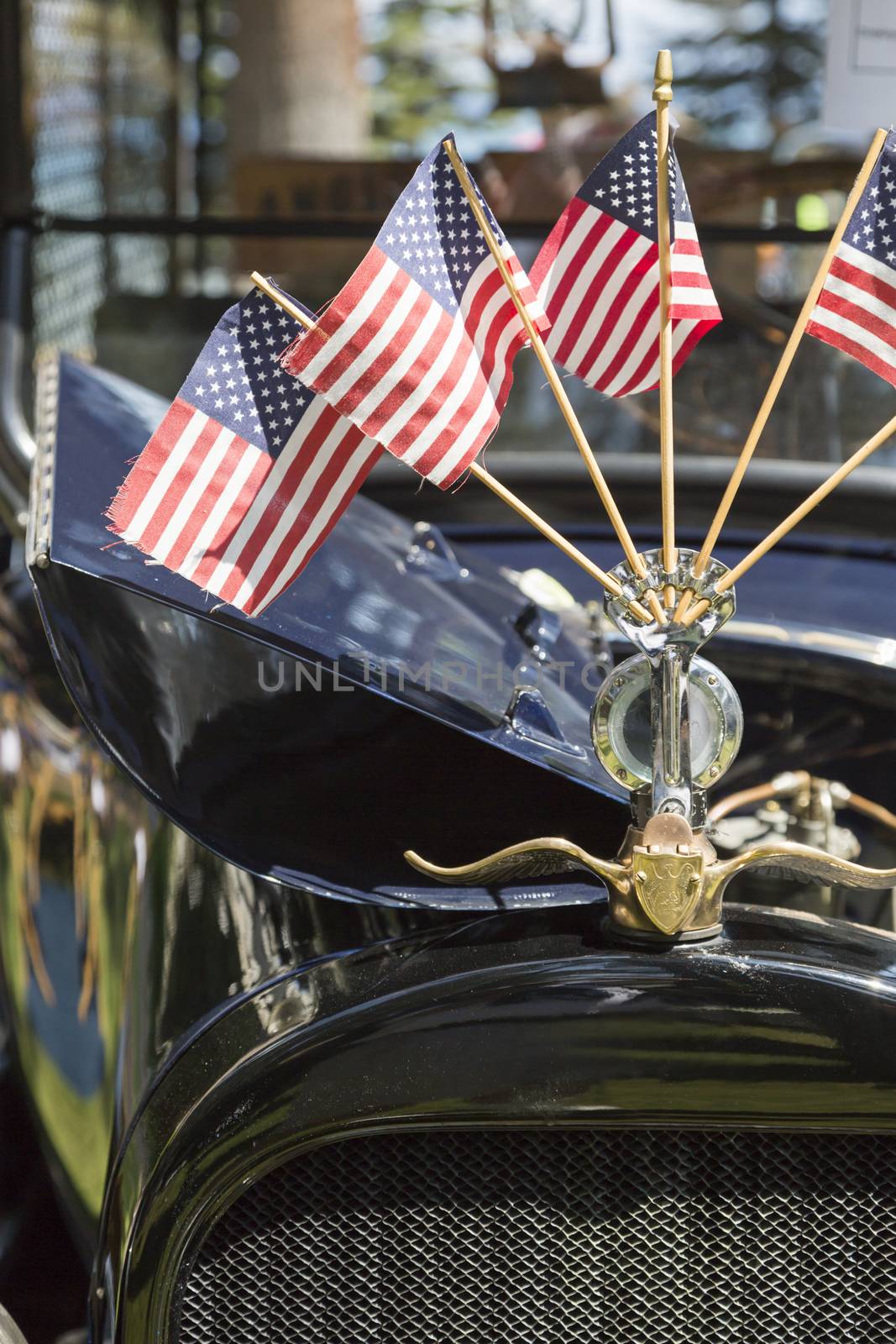 American Flags On Hood Ornament of Classic Vintage Car.