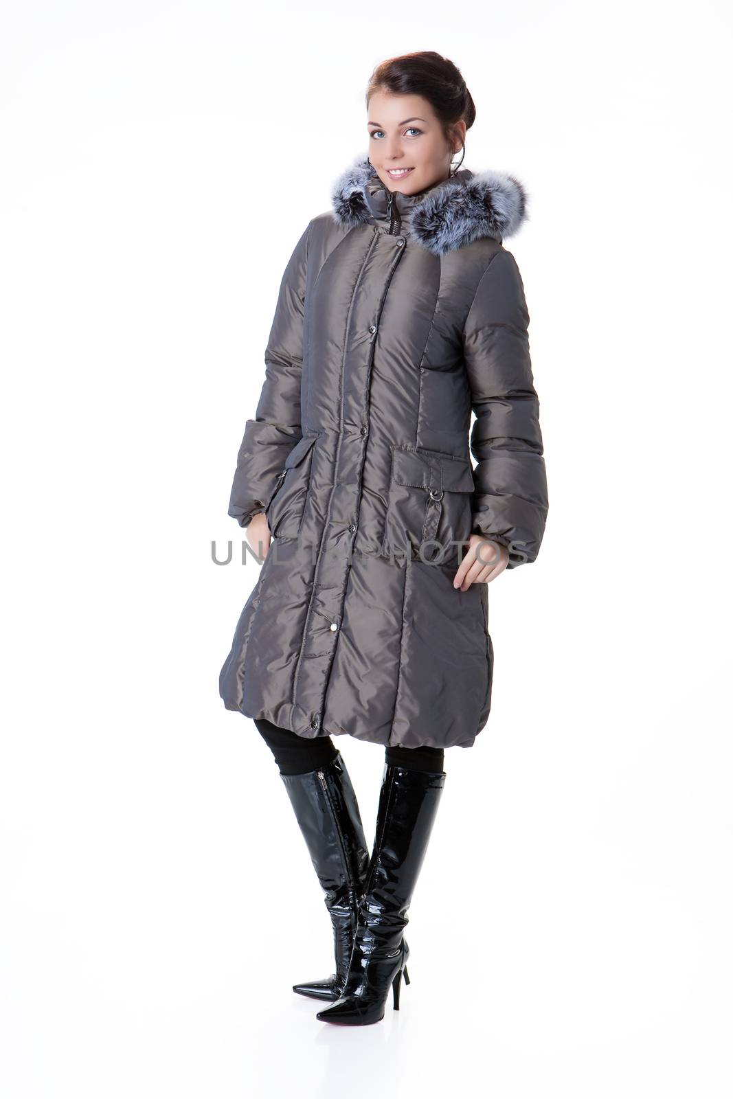 Young beautiful woman in fashionable winter warm clothing on isolated studio background