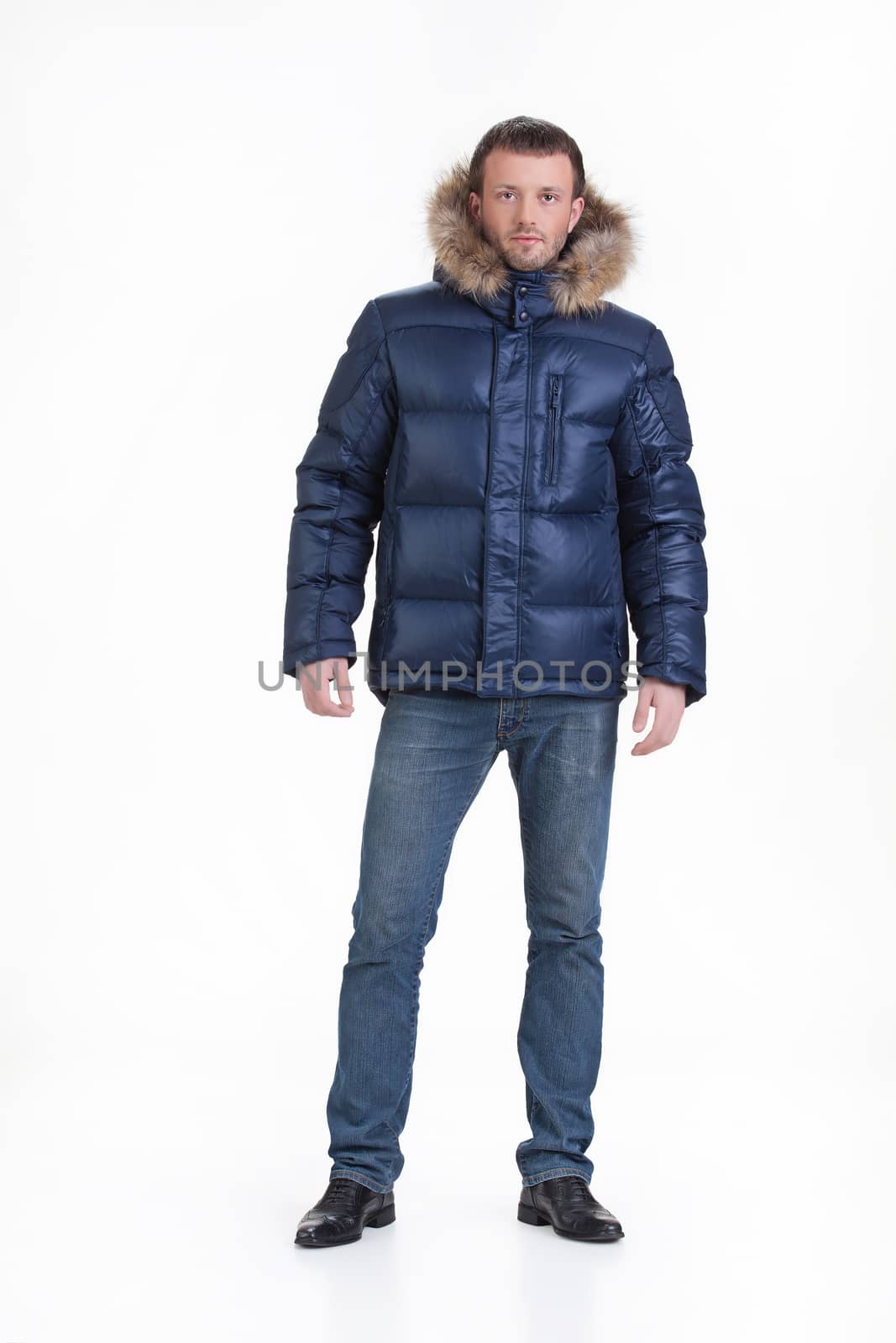 Young man in fashionable winter clothing on isolated studio background