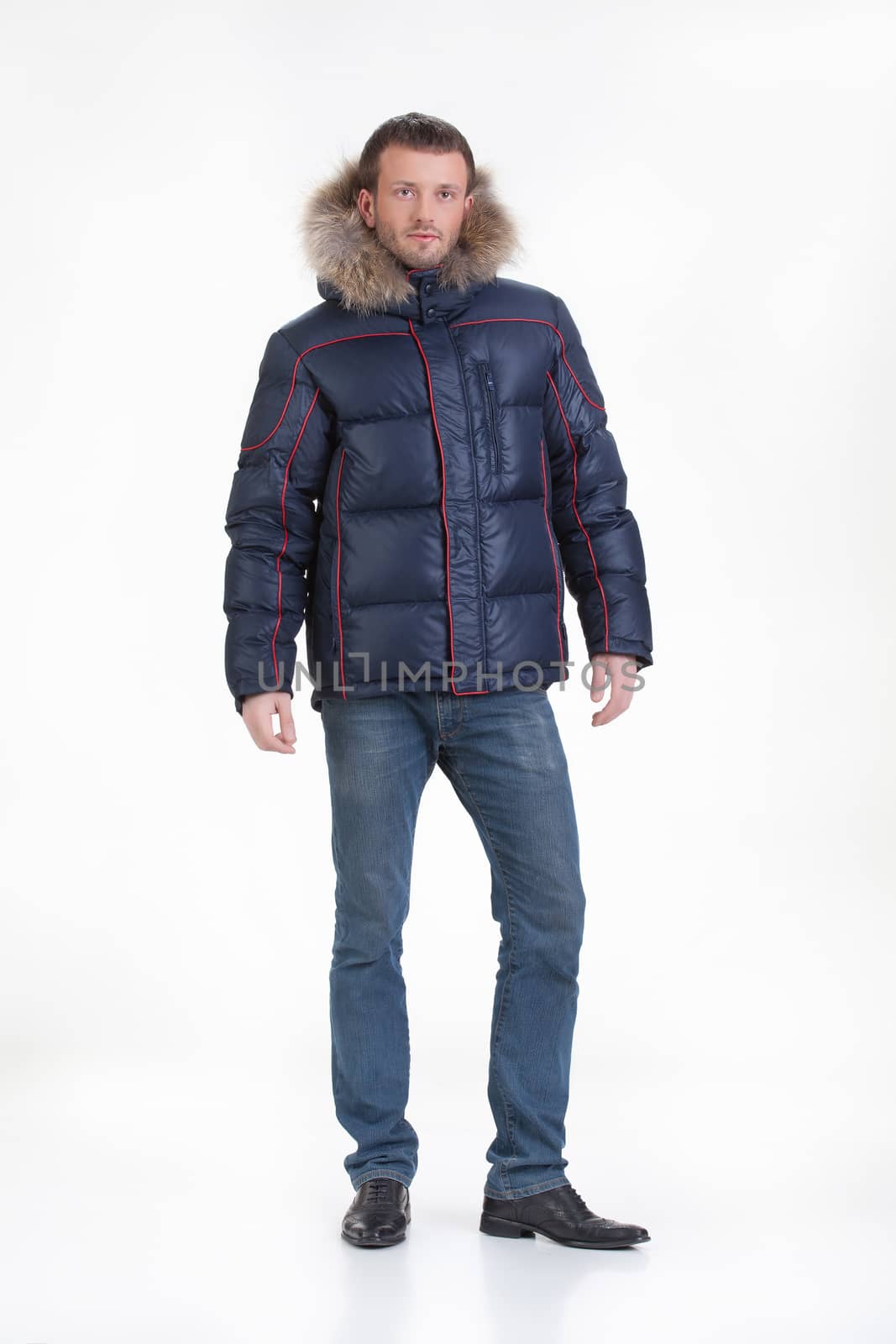 Young man in fashionable winter clothing on isolated studio background