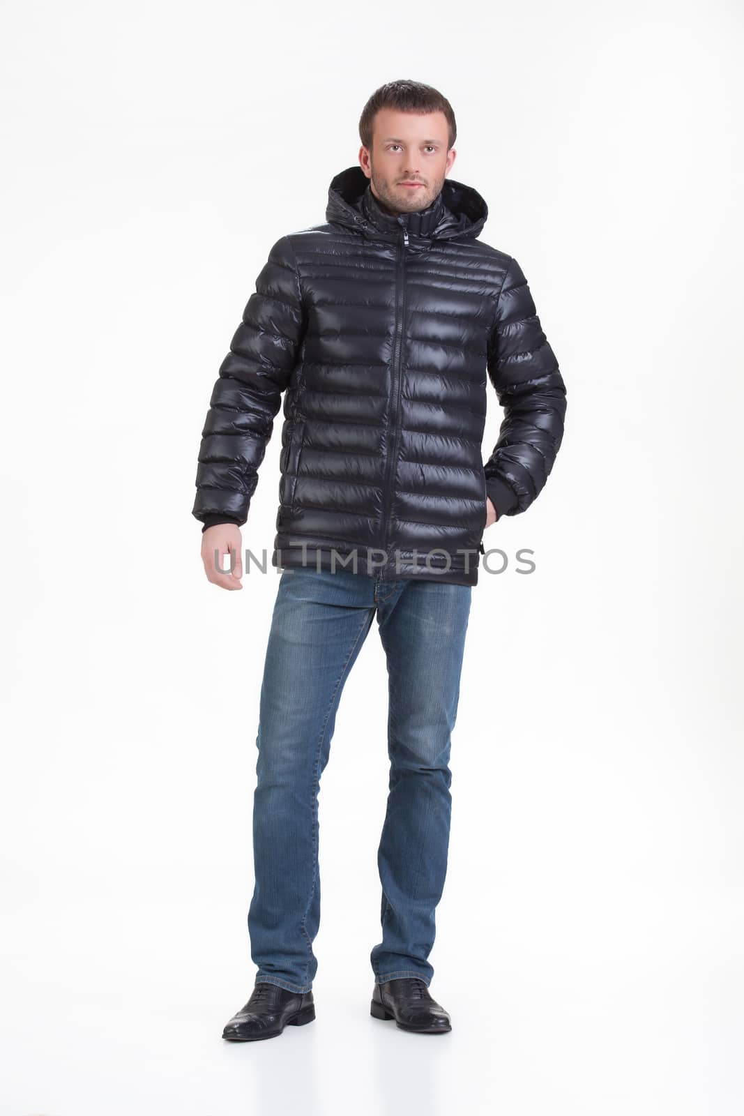 Young man in fashionable winter clothing on isolated studio background