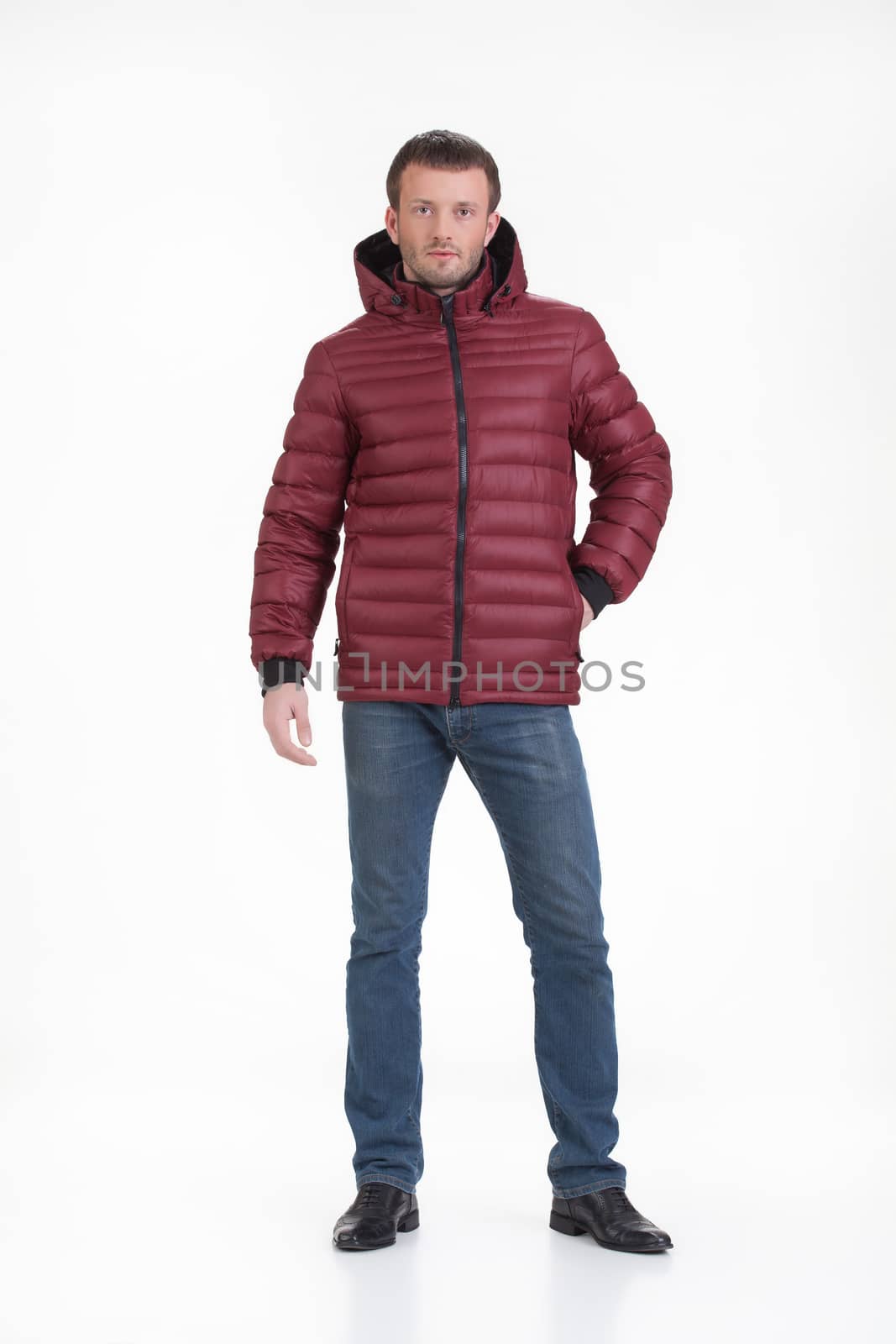Young man in fashionable winter clothing on isolated studio background