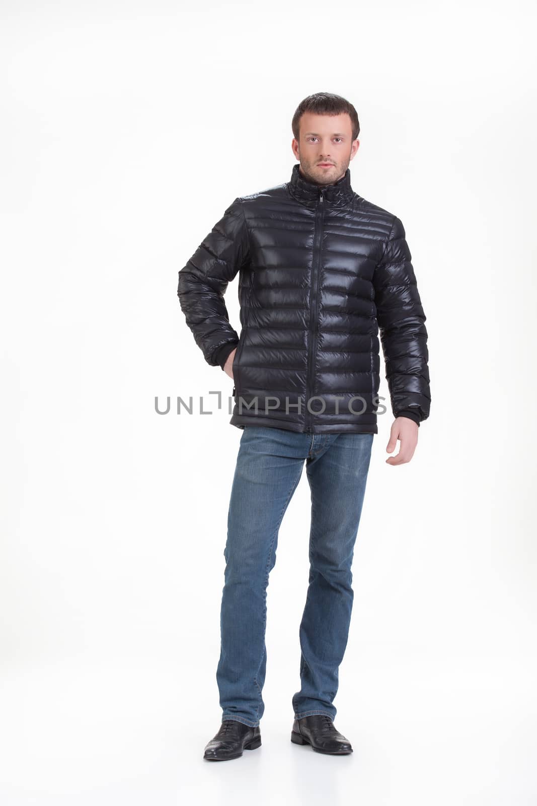 Young man in fashionable winter clothing on isolated studio background