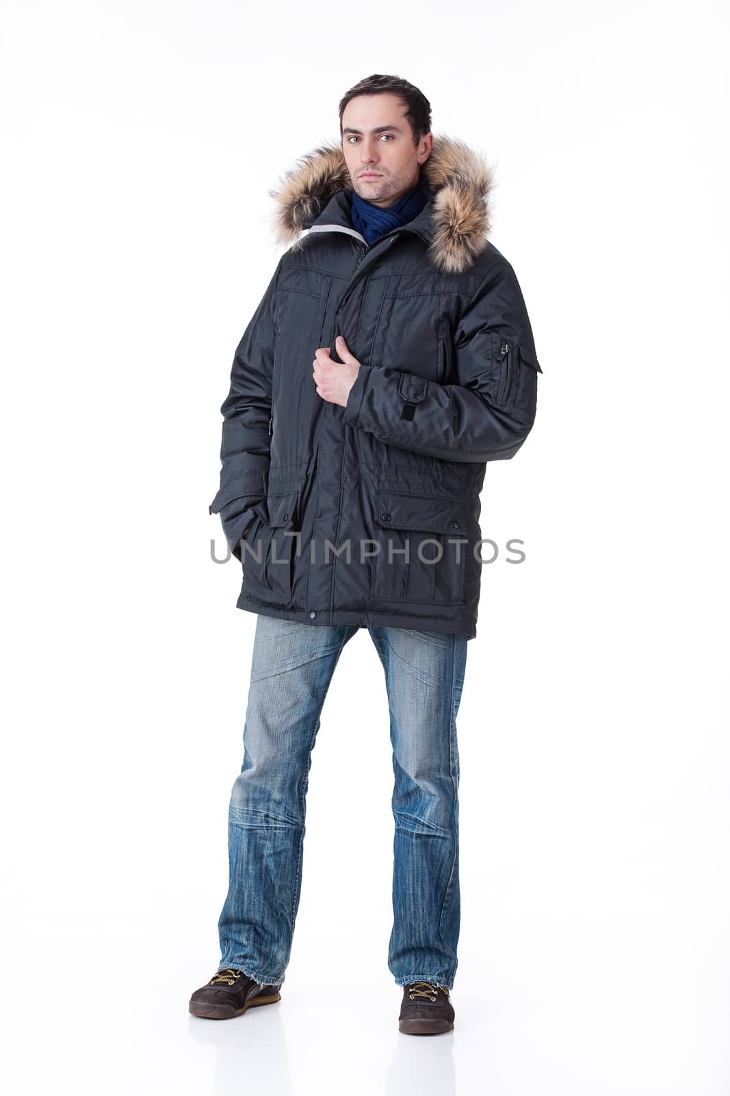 Young man in winter warm clothing on isolated background