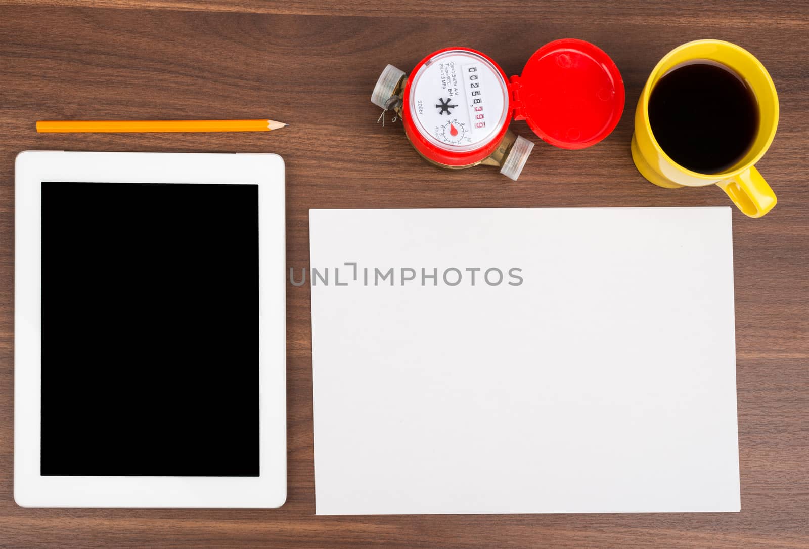 Blank paper with tablet and water meter on wooden table
