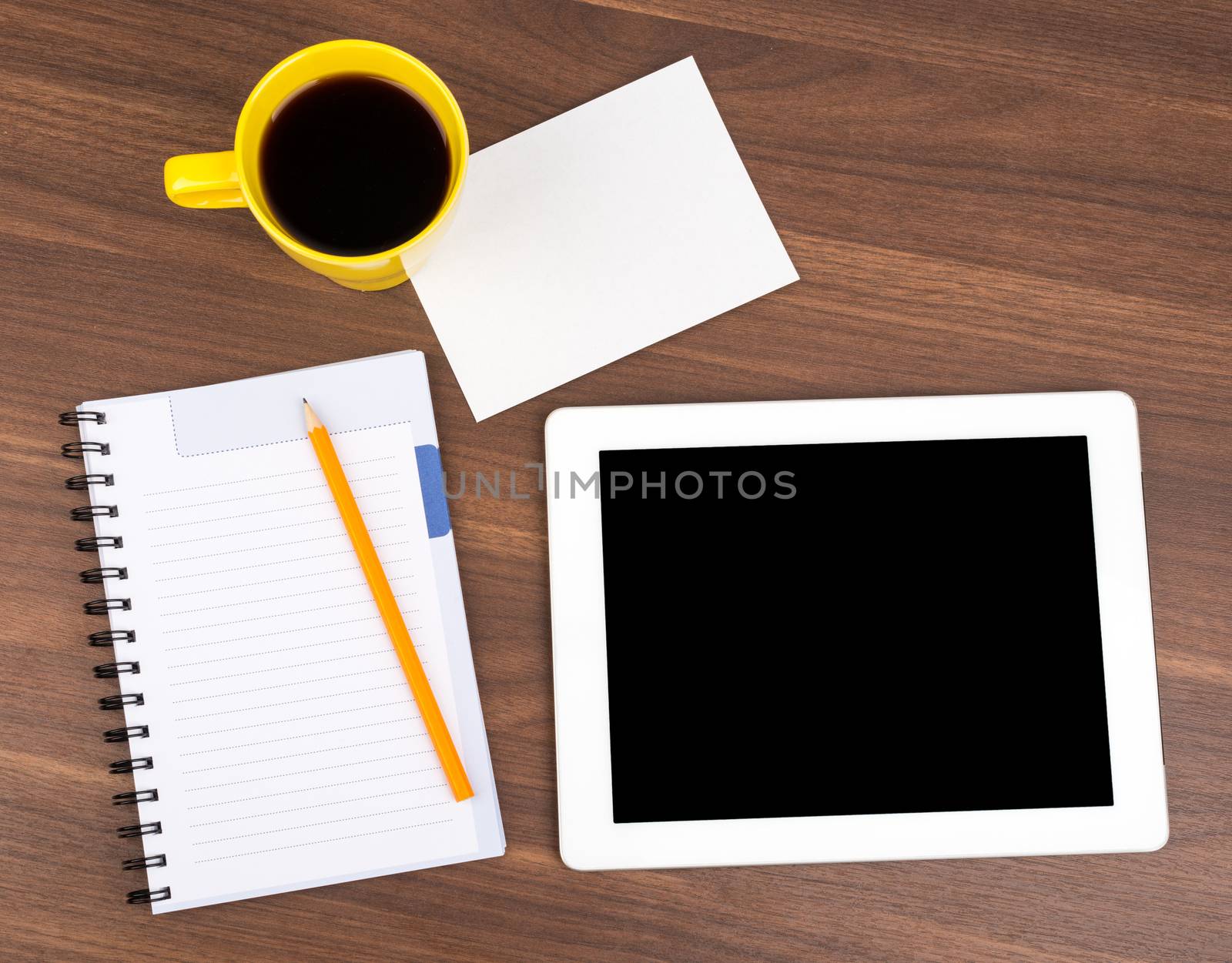 Blank copybook with tablet and small card on wooden table