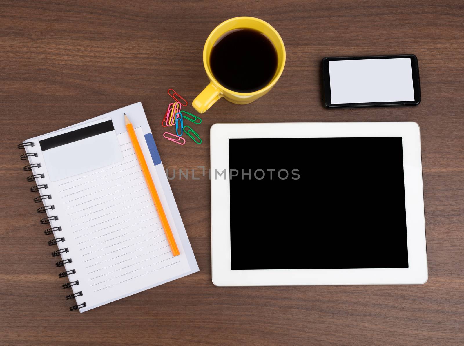 Blank copybook with tablet and coffee on wooden table