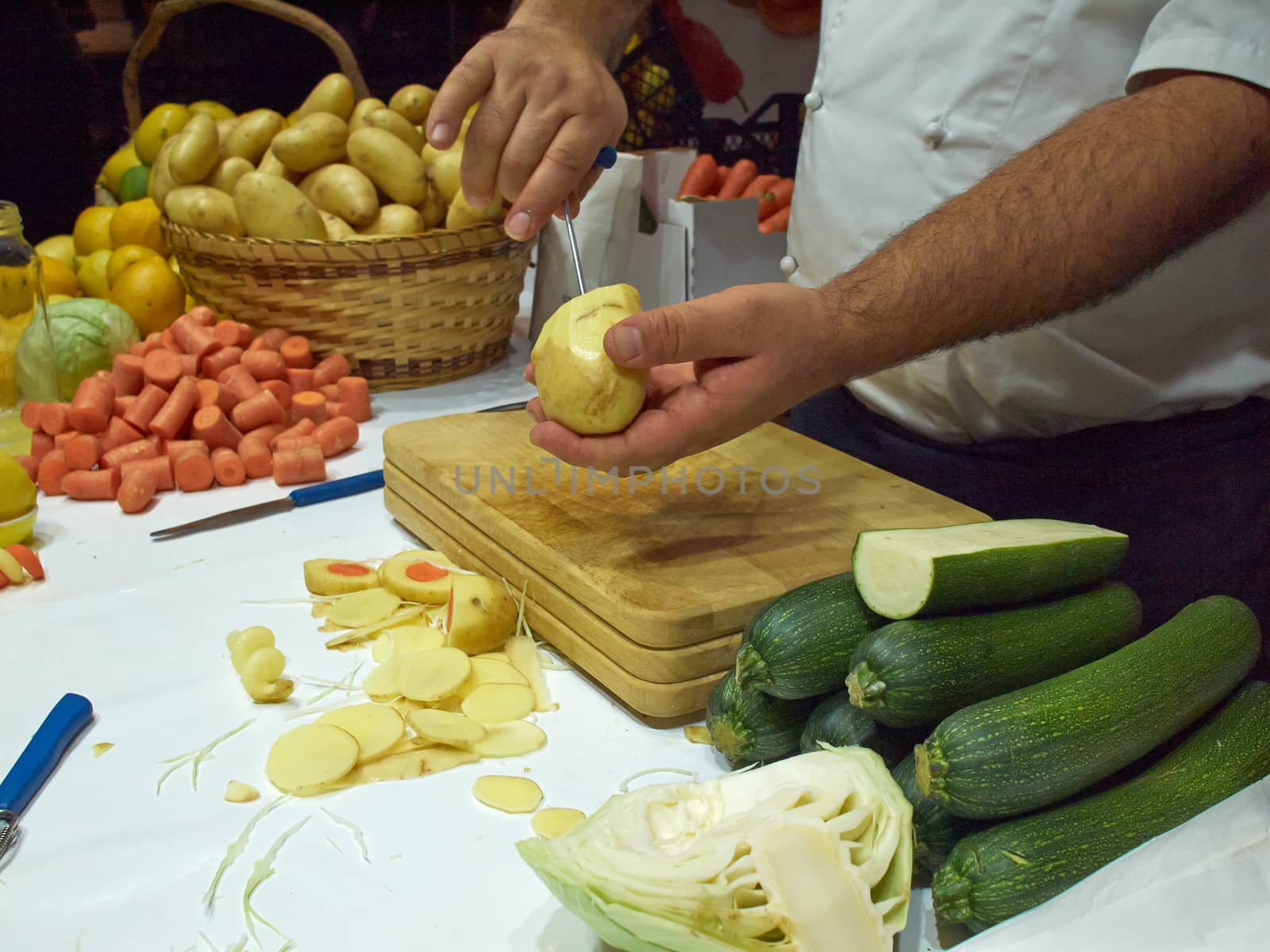 Vegetables on cutting board and chef cutting them for a soup