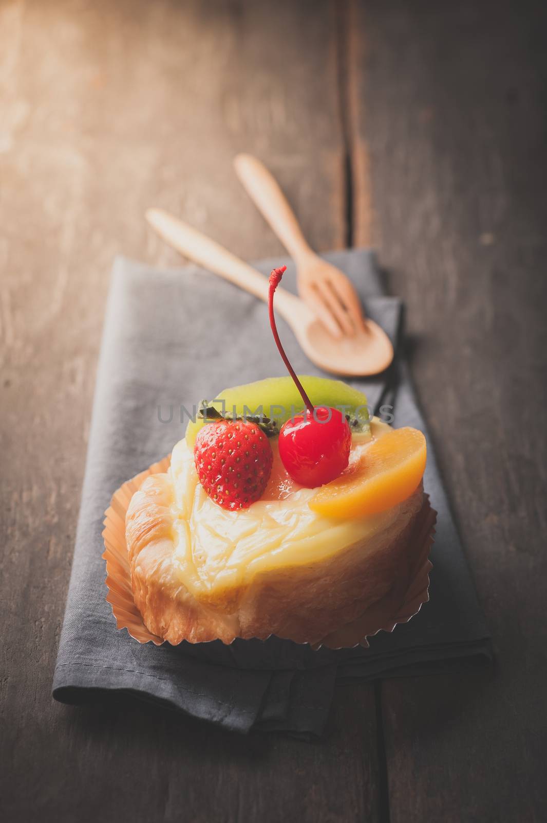 Fruit danish pastry on wood table in morning time with film filter effect