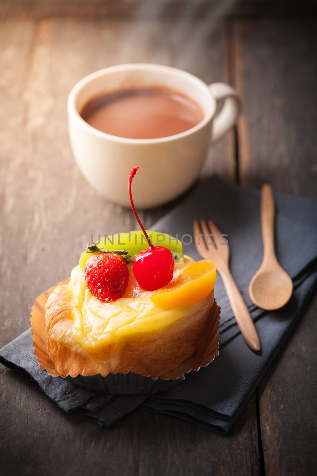 Fruit danish pastry with hot chocolate on wood table with morning scene
