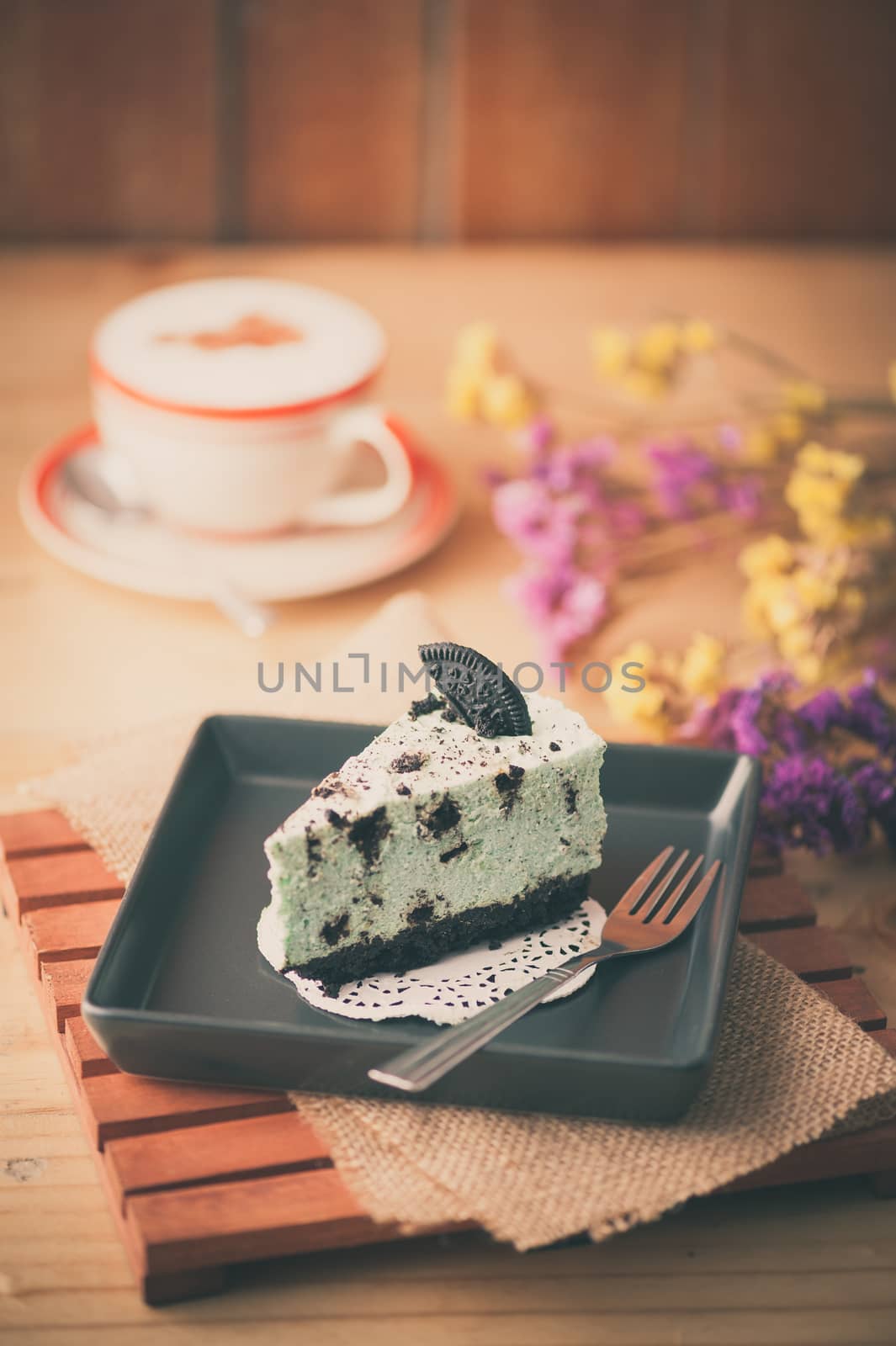 Peppermint with chocolate cookie cheese cake and hot cappuccino at cafe in afternoon time with film filter effect