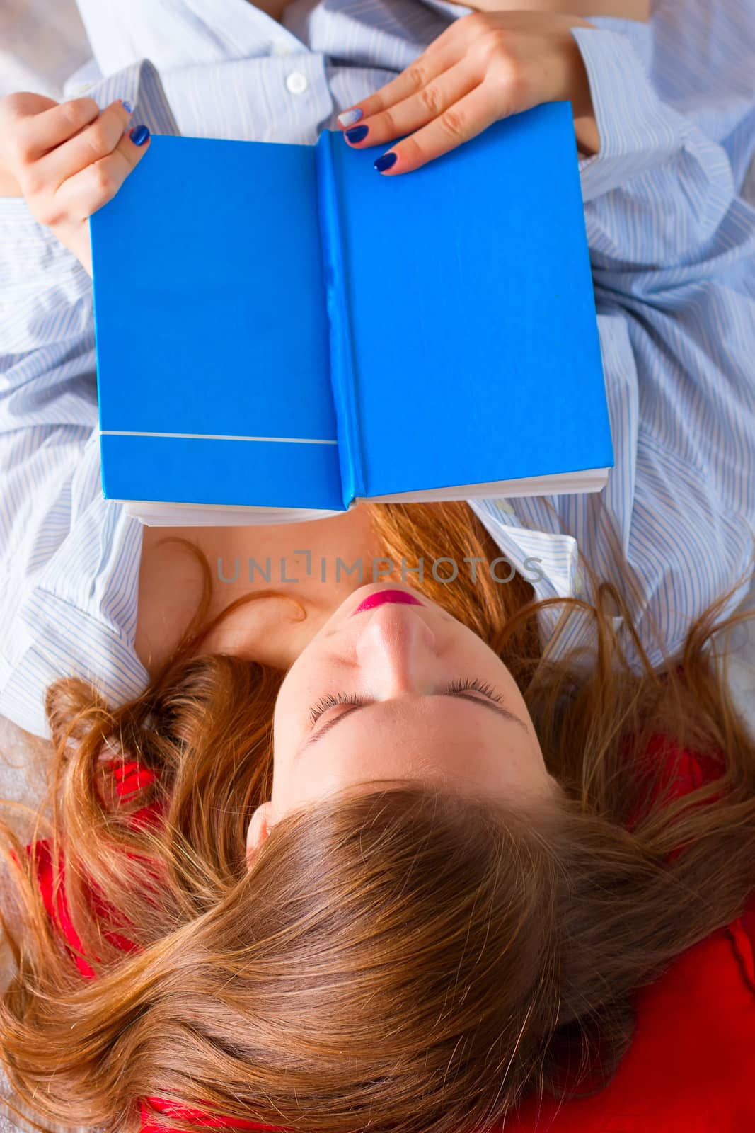 girl in a man's shirt is reading book by victosha