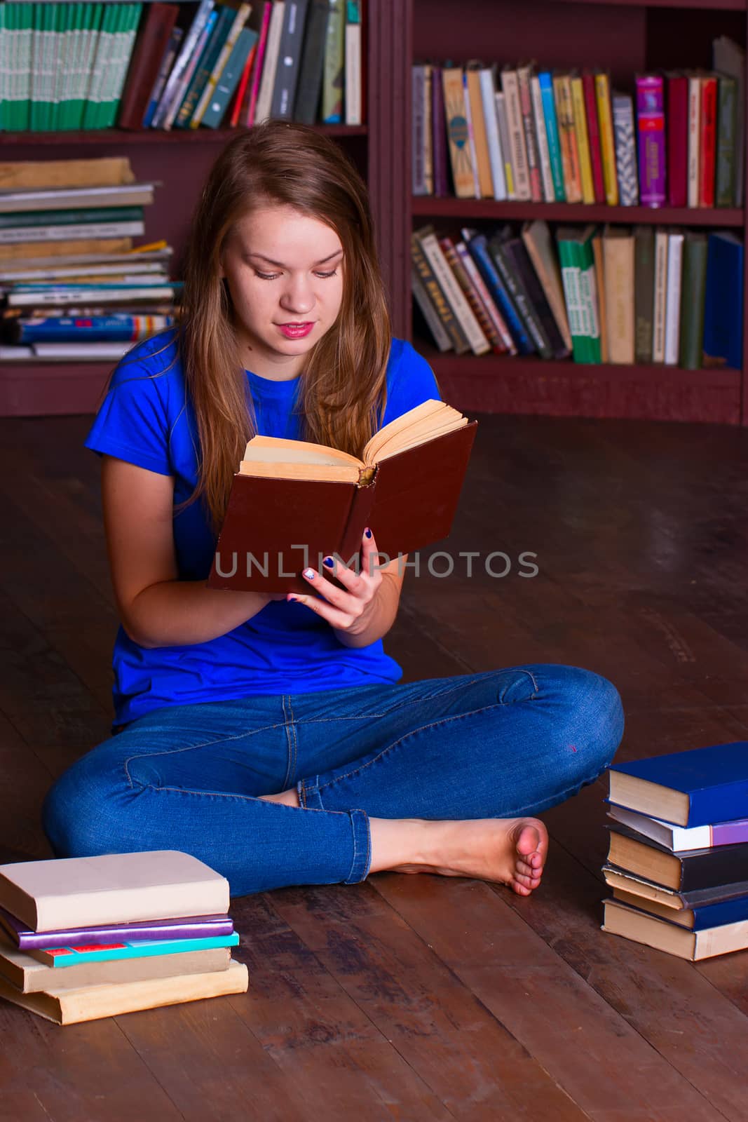 A girl sits on the floor in the library