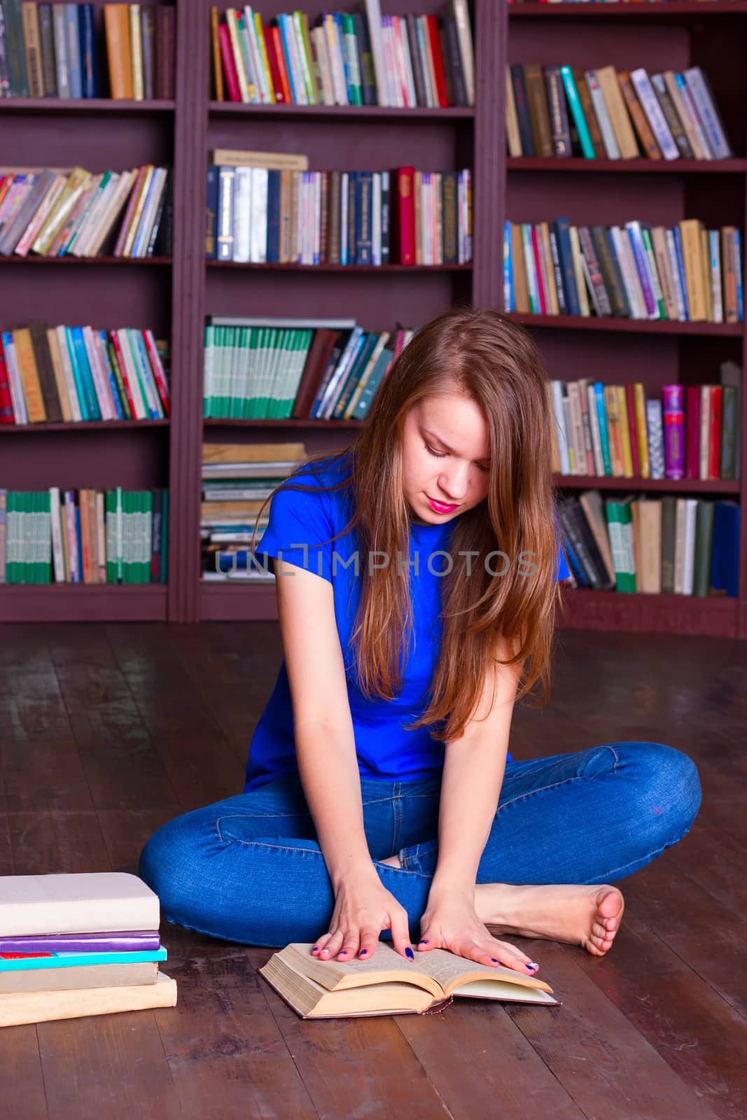 girl sits on floor in the library by victosha