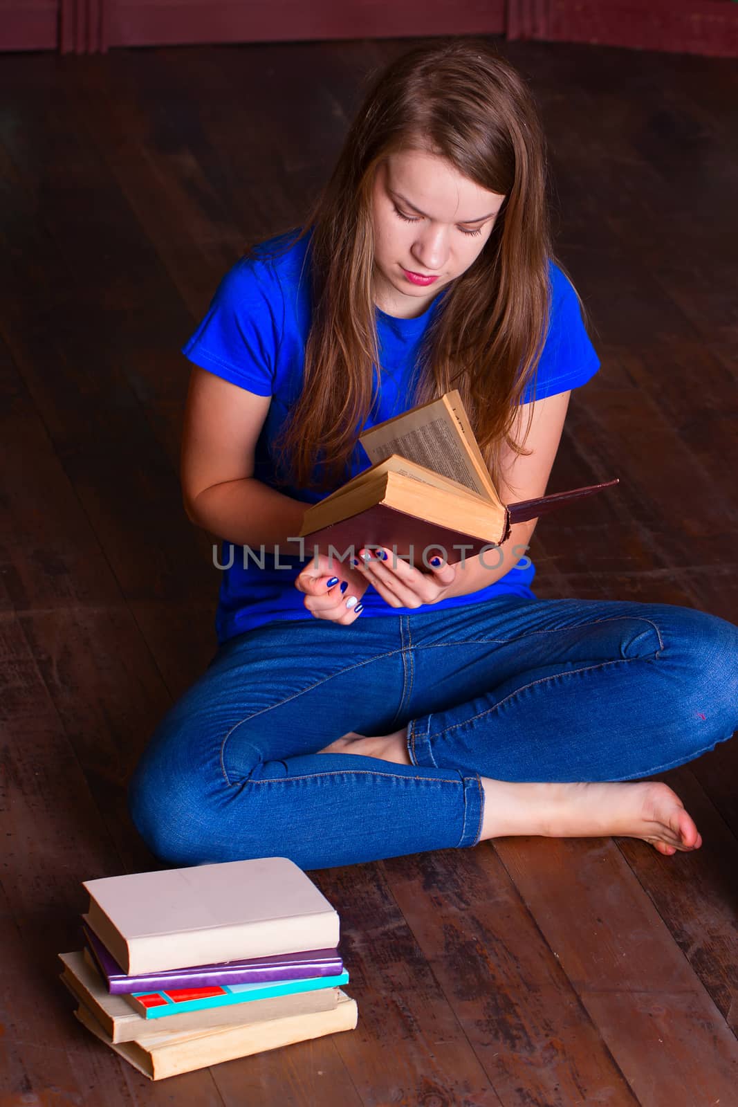 A girl sits on the floor in the library