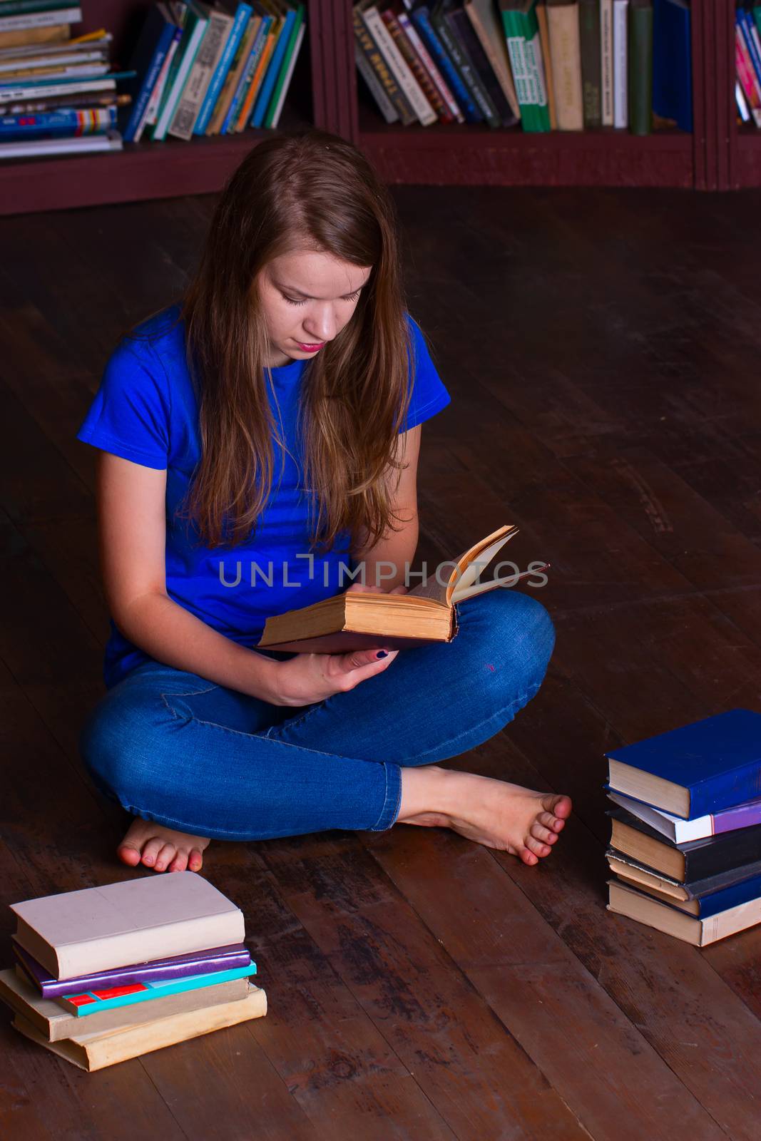 girl sits on floor in the library by victosha