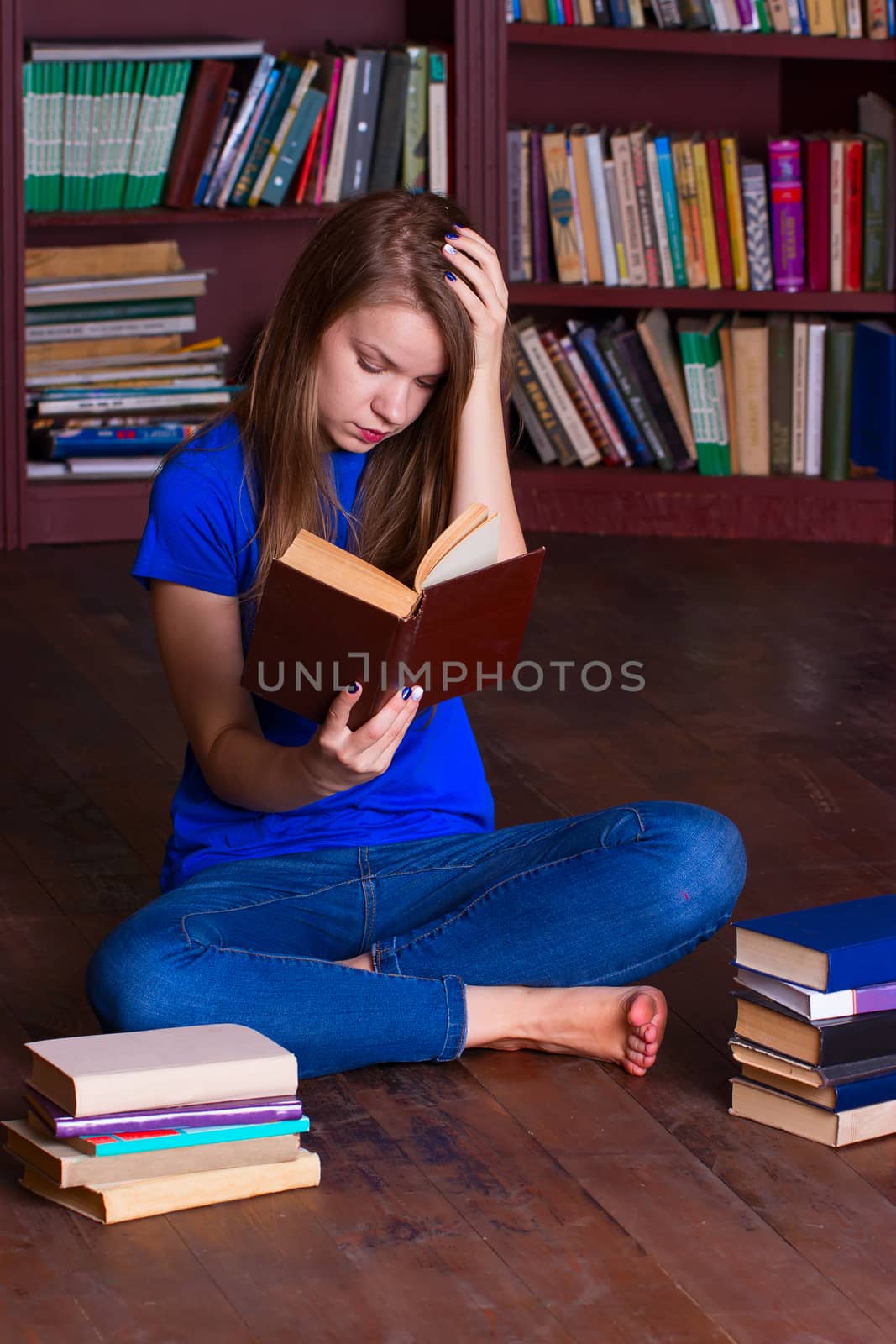 A girl sits on the floor in the library