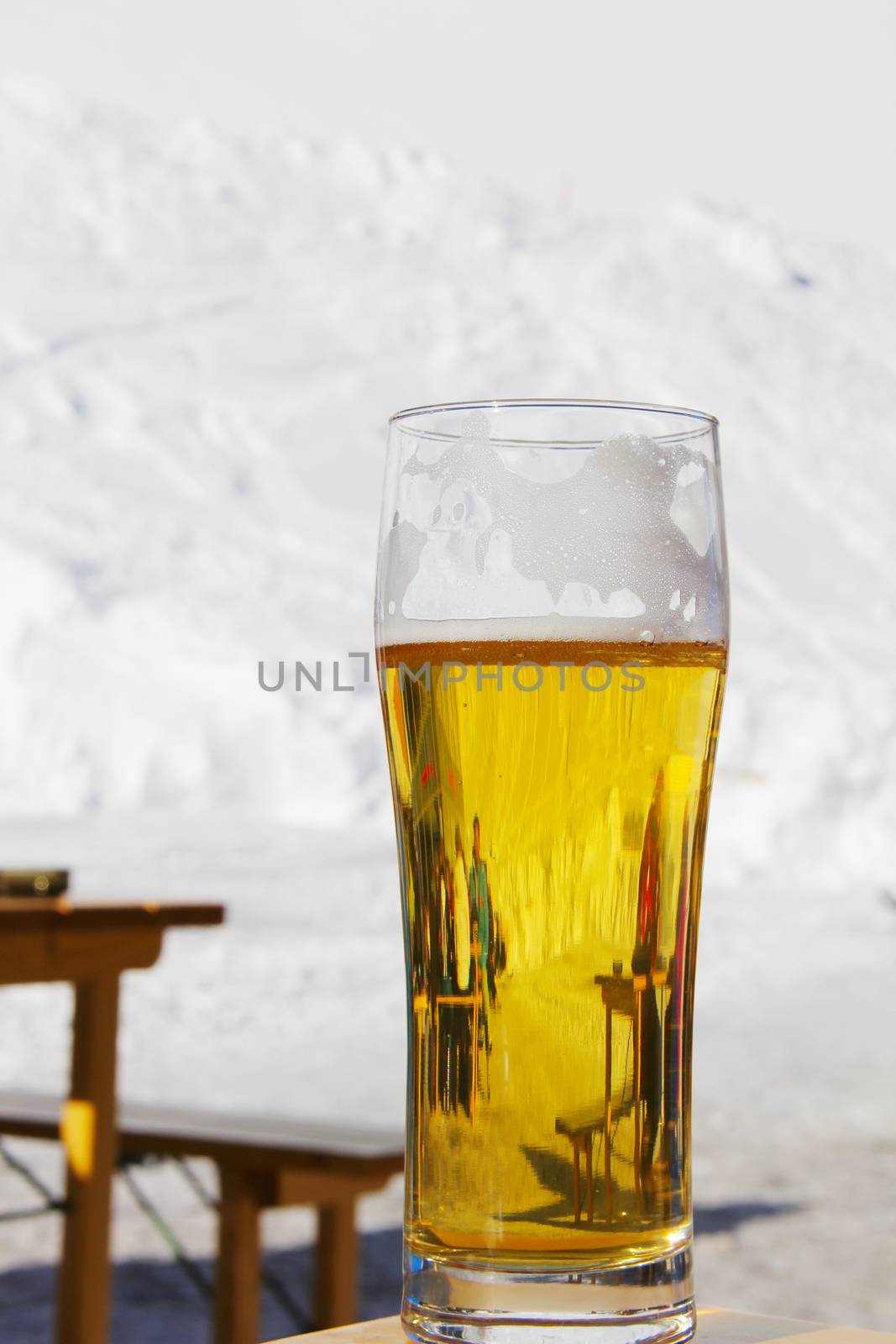 Glass with beer on a wooden table in high mountain cafe