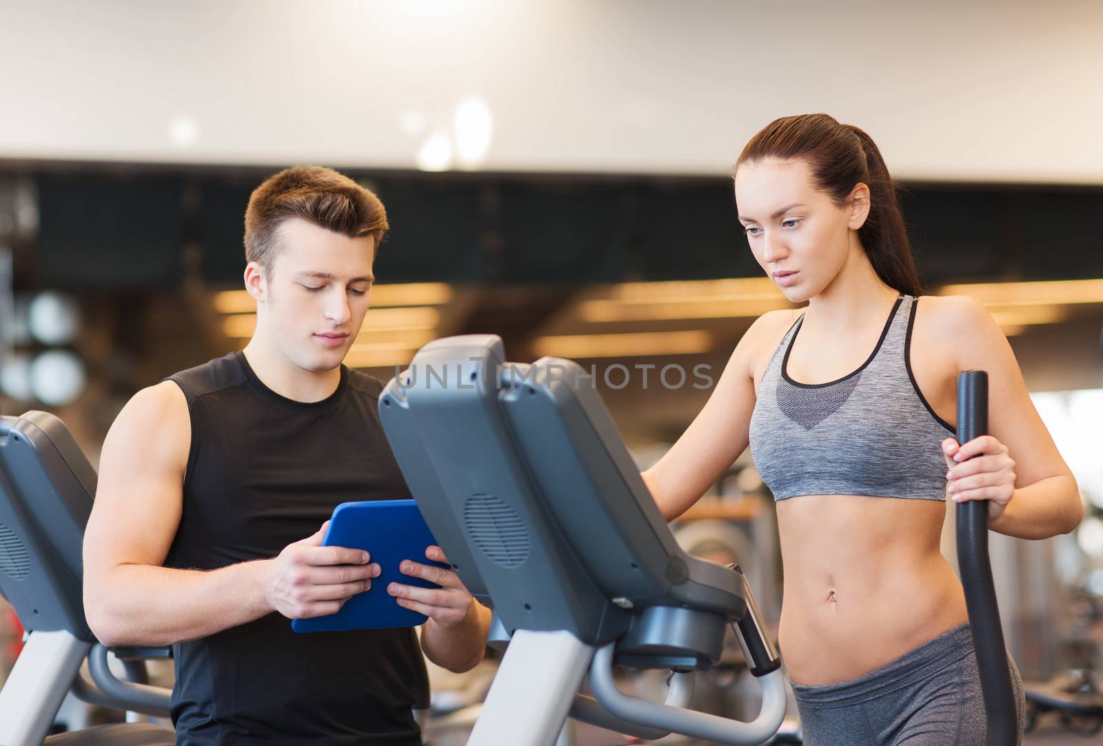 woman with trainer exercising on stepper in gym by dolgachov