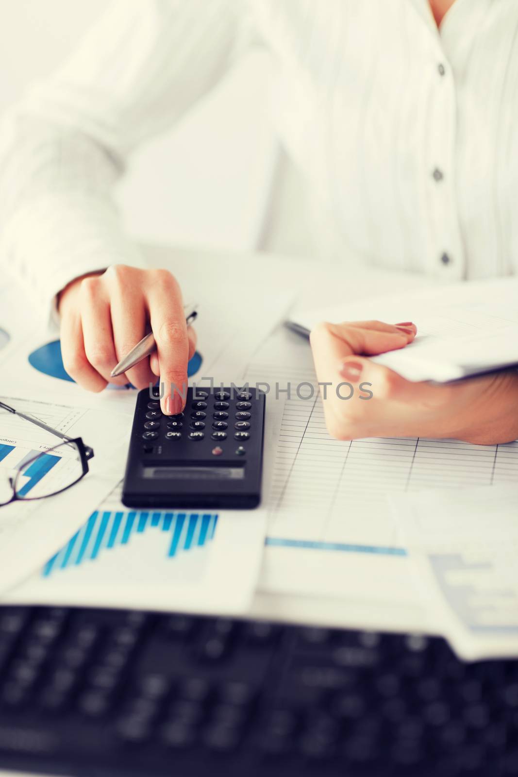 business, office, school and education concept - woman hand with calculator and papers
