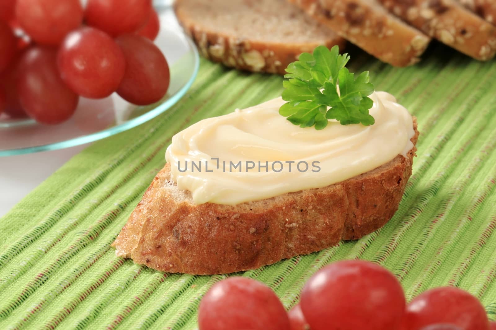 Slice of bread roll and creamy cheese spread