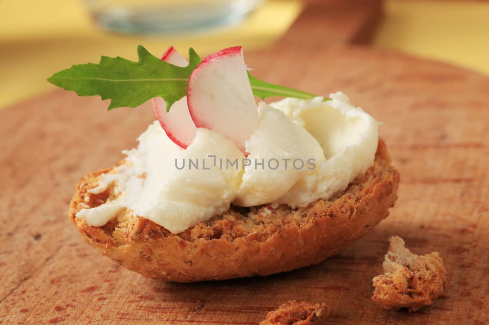 Crispy roll with cheese spread on cutting board