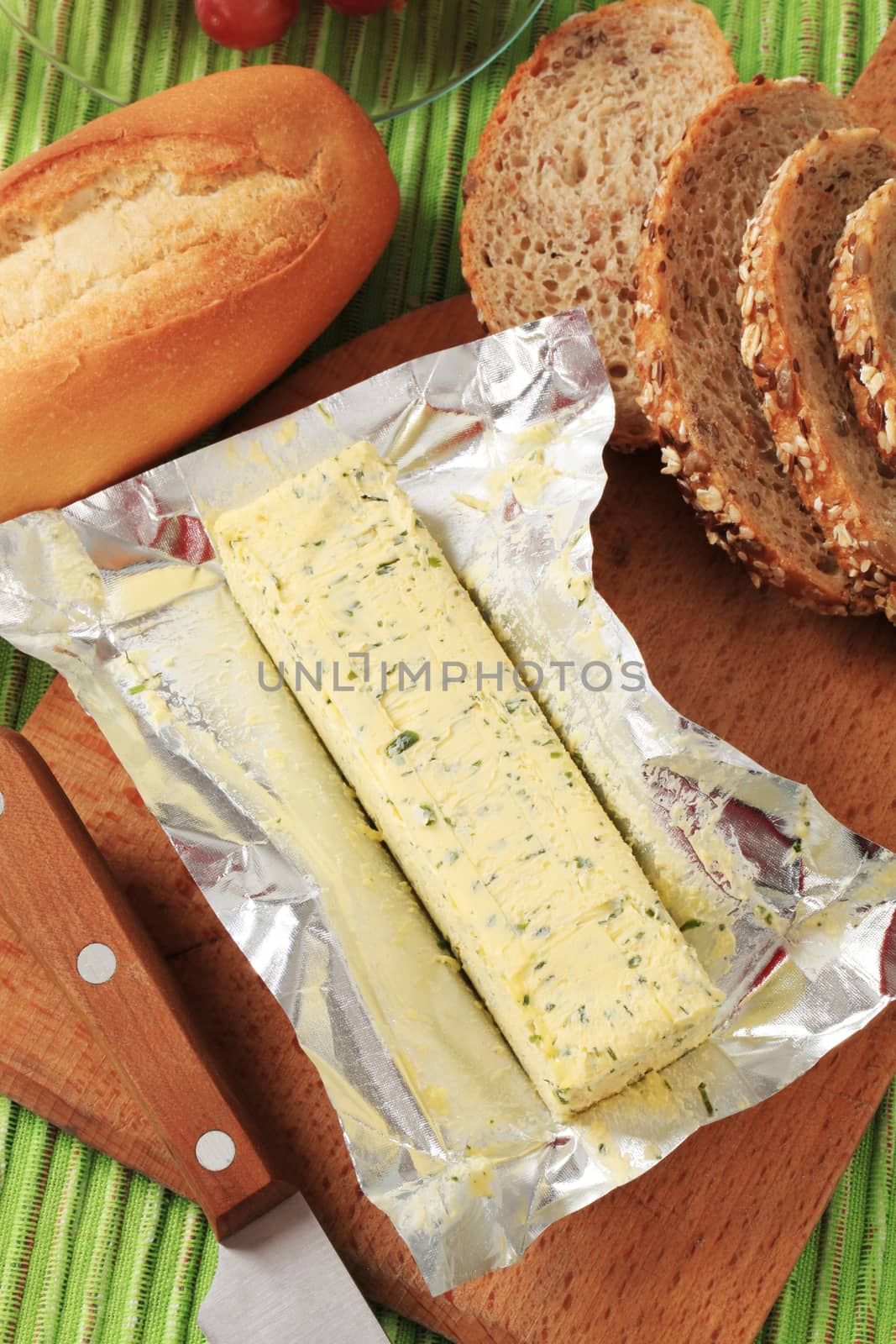 Stick of fresh herb butter and bread 