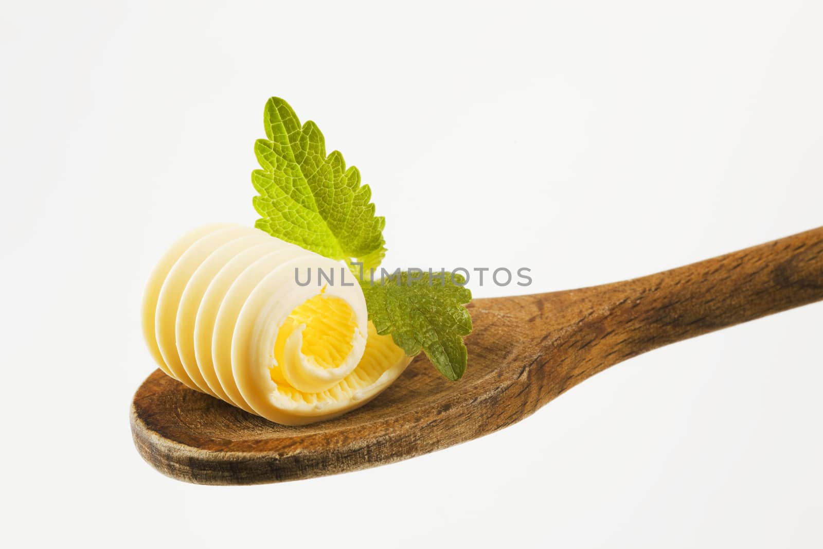 Closeup of butter curl on a wooden spoon 
