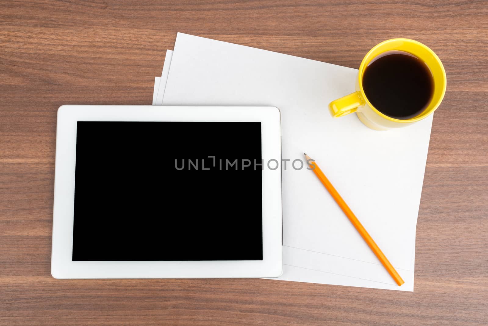 Tablet with blank paper and coffee on wooden table