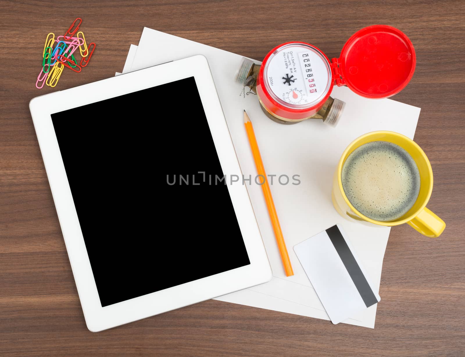 Tablet with blank paper and coffee on wooden table