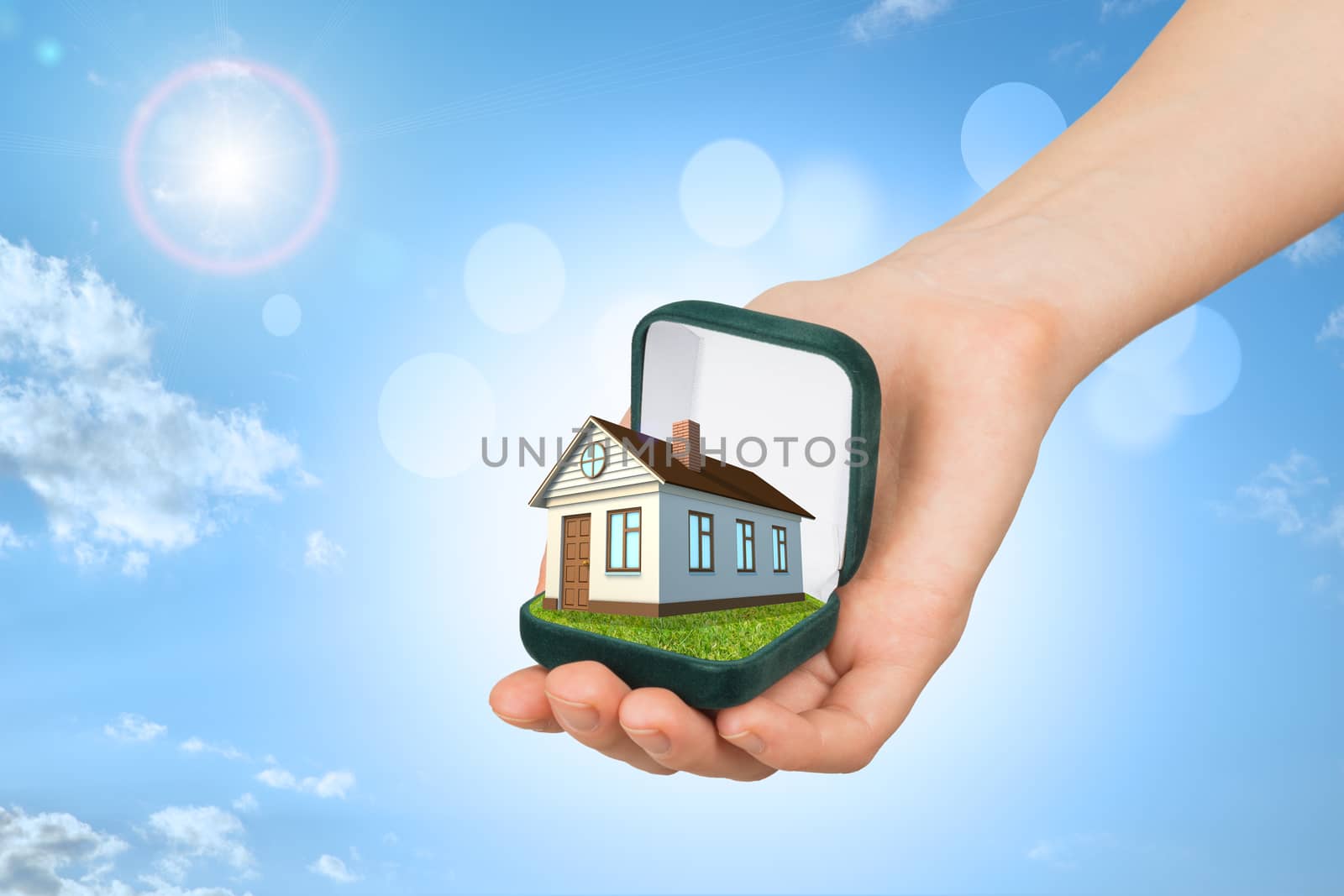 Empty ring box house in humans hand on blue sky background