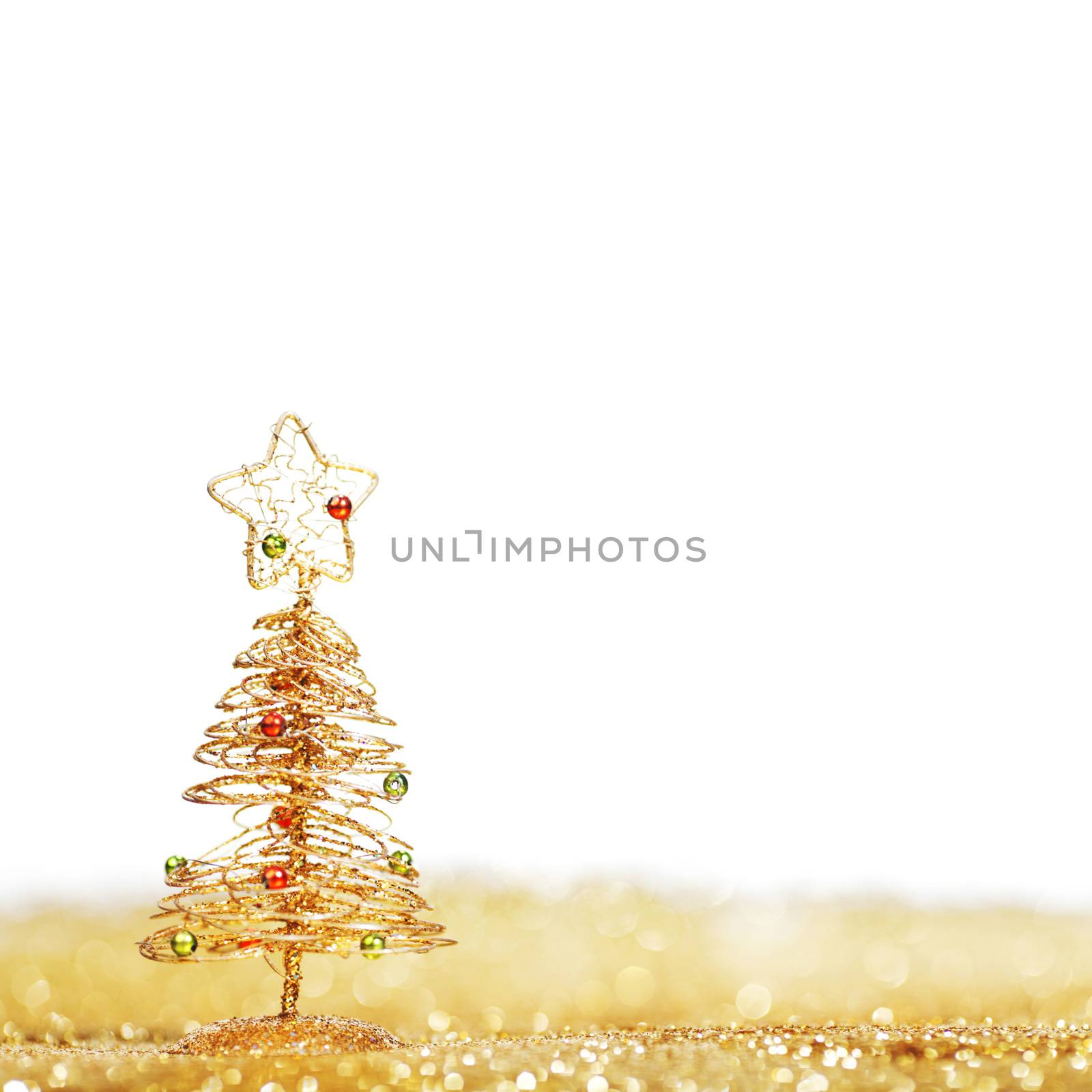 Toy golden decorative Christmas tree on glitter background