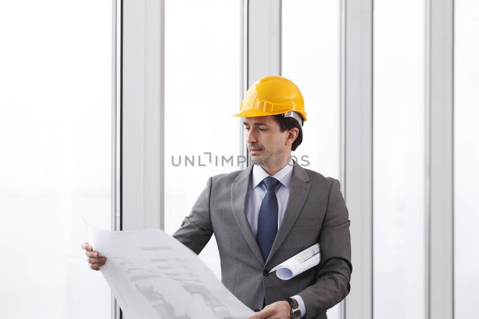 Architector in hardhat and business suit with construction plans