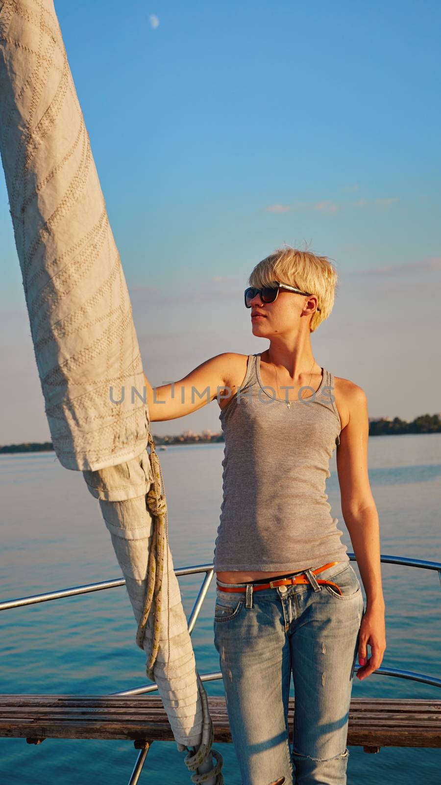 Woman traveling by boat at sunset by sarymsakov