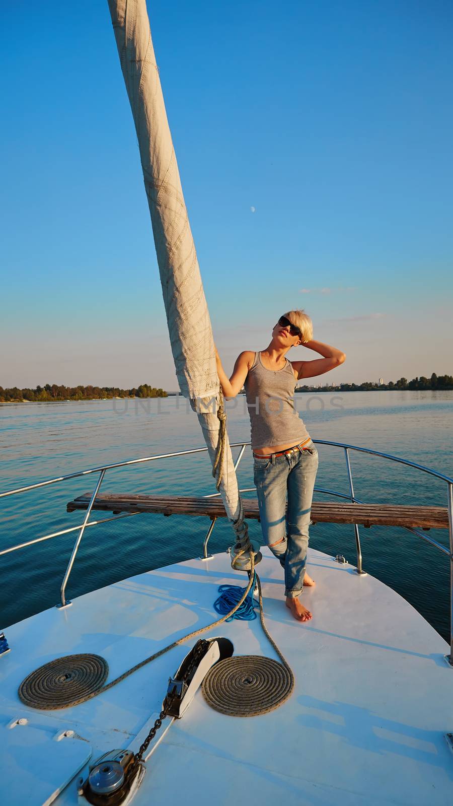 Woman traveling by boat at sunset by sarymsakov