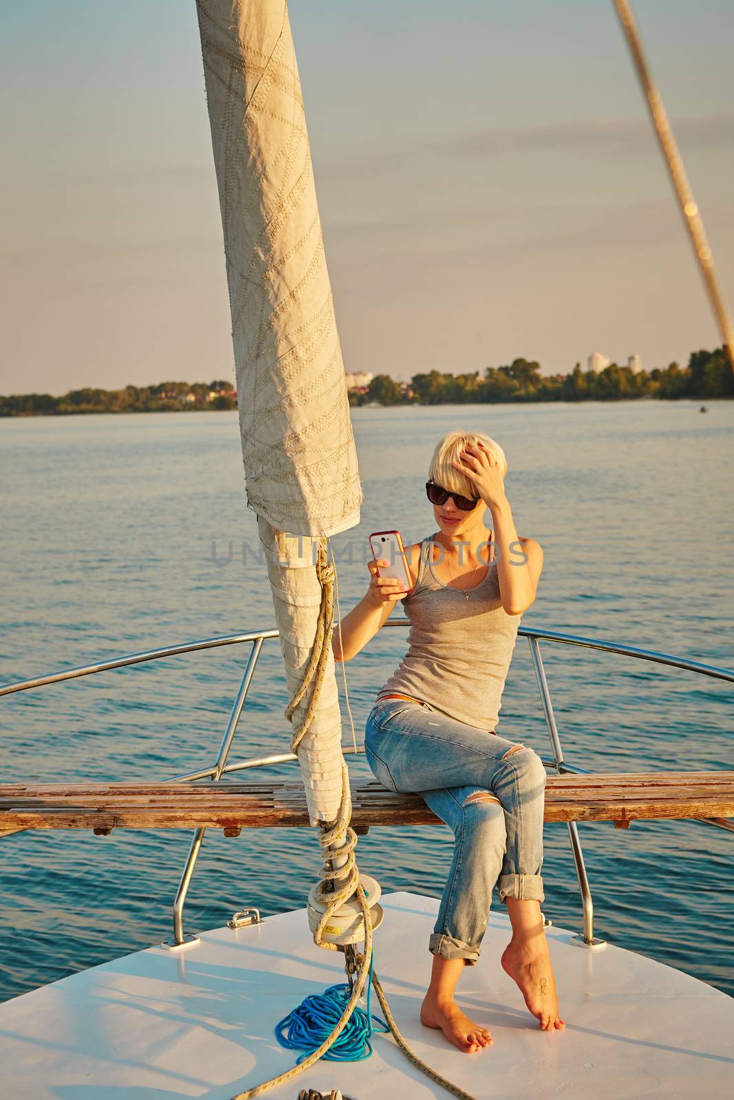 Pretty young female tourist makes selfie on yacht by sarymsakov