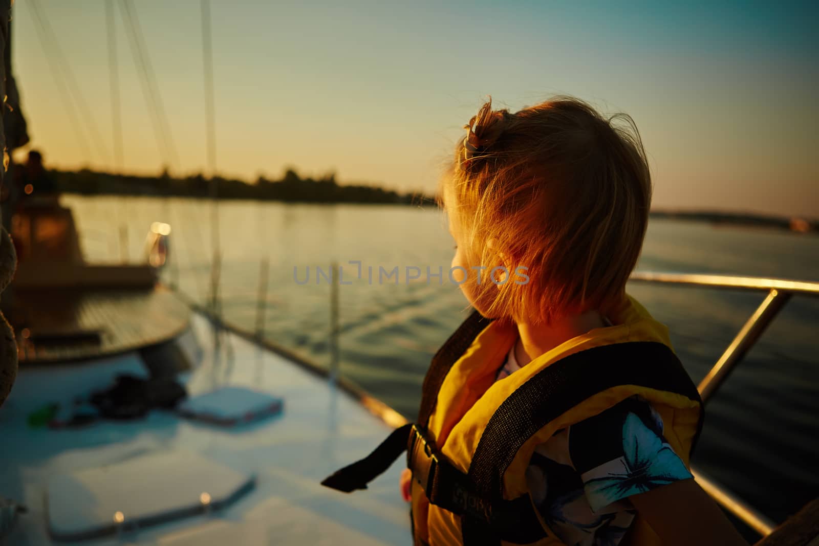 Little girl enjoying ride on yacht at sunset