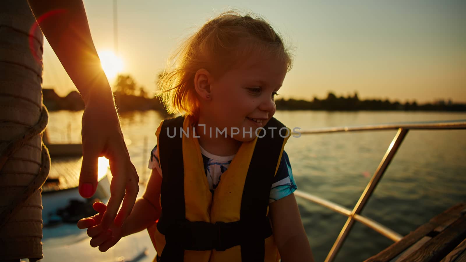 Little girl enjoying ride on yacht at sunset