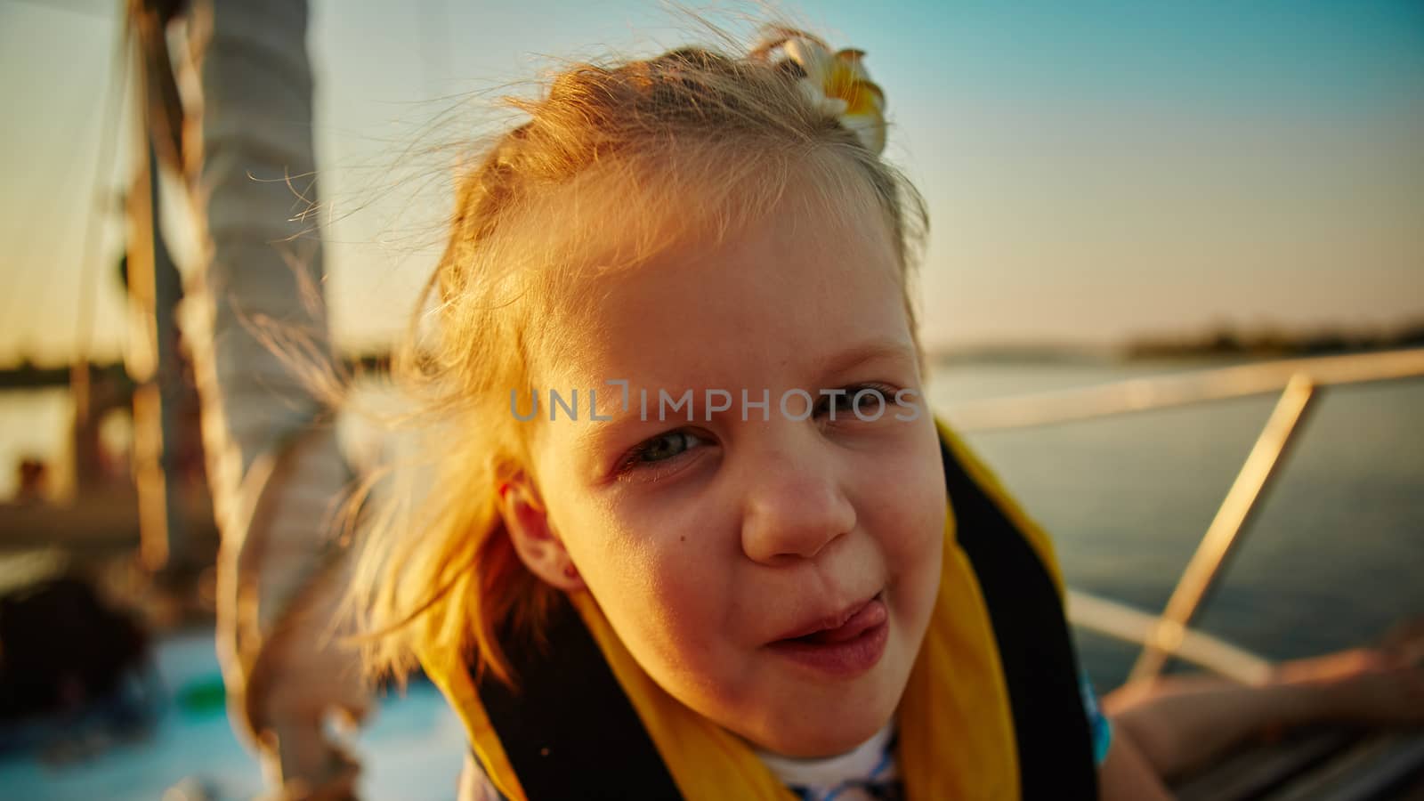 Little girl enjoying ride on yacht at sunset