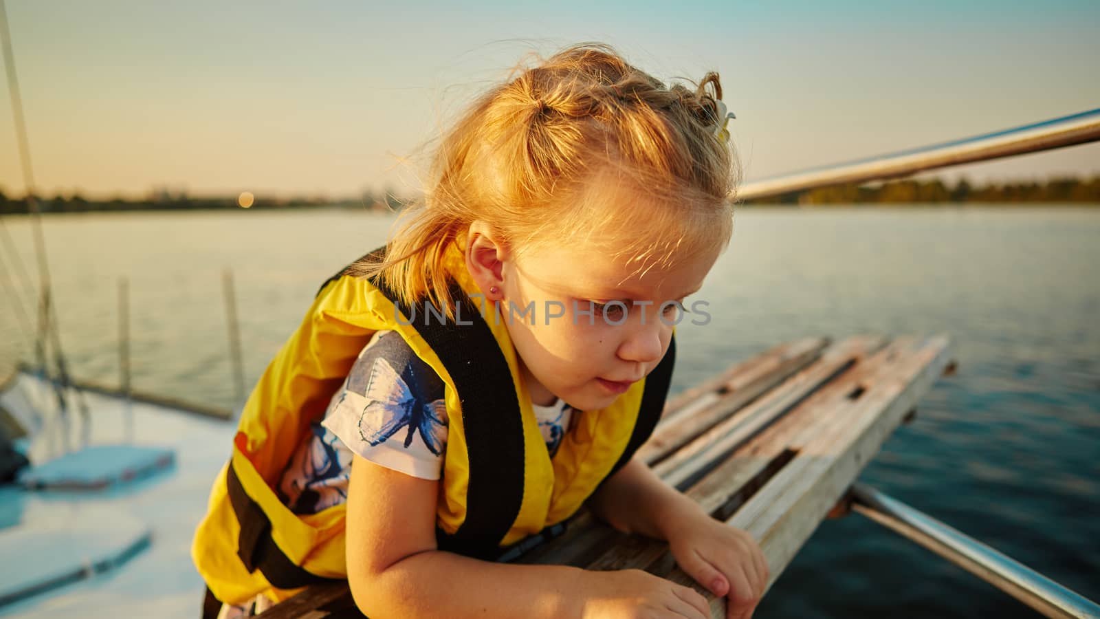 Little girl enjoying ride on yacht at sunset