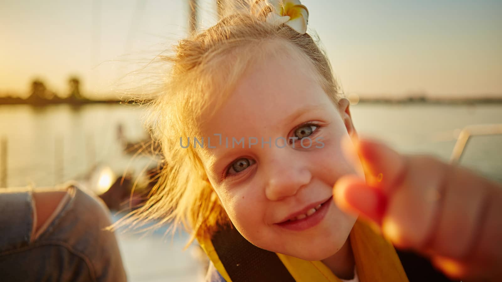 Little girl enjoying ride on yacht at sunset