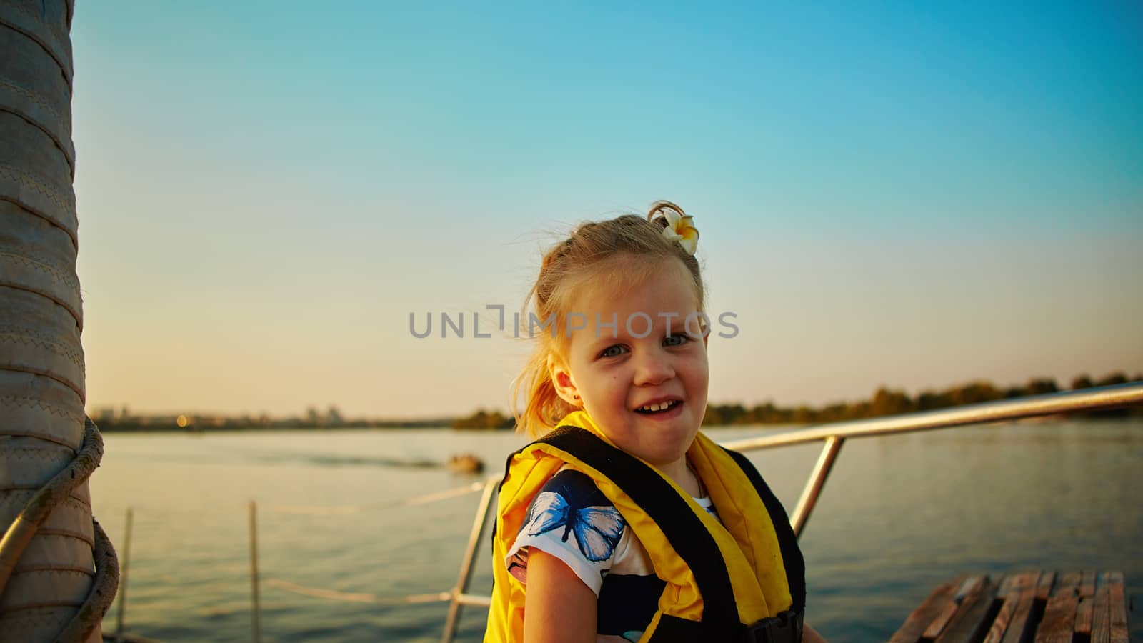 Little girl enjoying ride on yacht at sunset