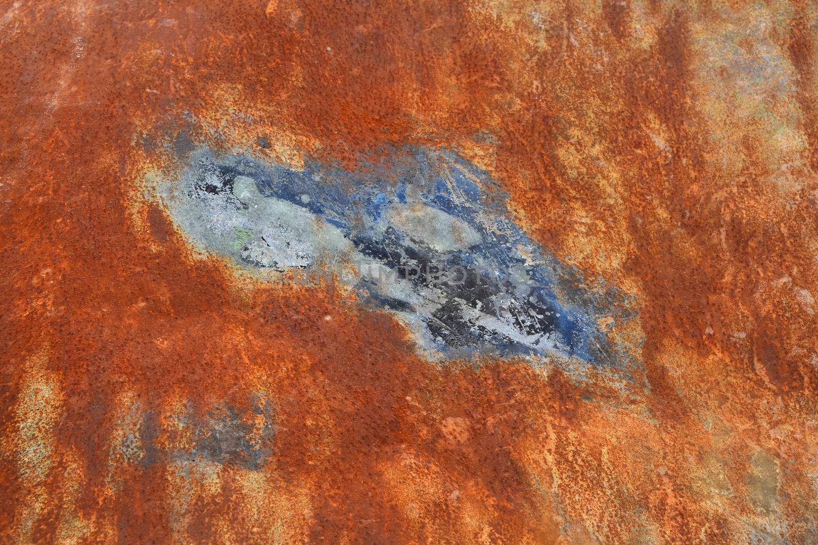 Bright rust stained corroded metal surface with uneven paint