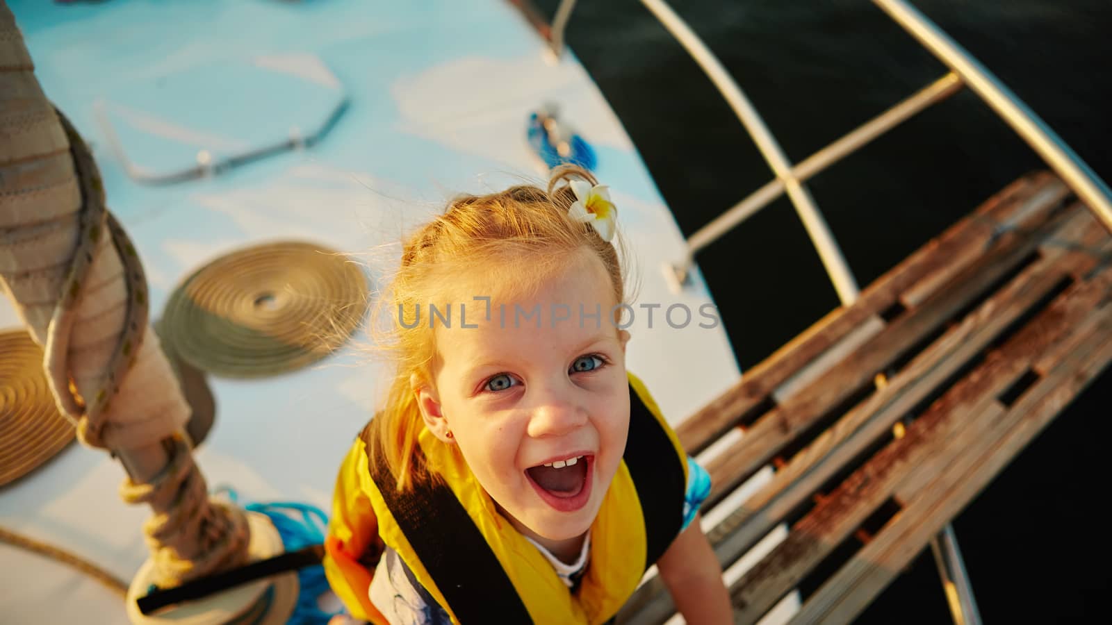 Little girl enjoying ride on yacht at sunset