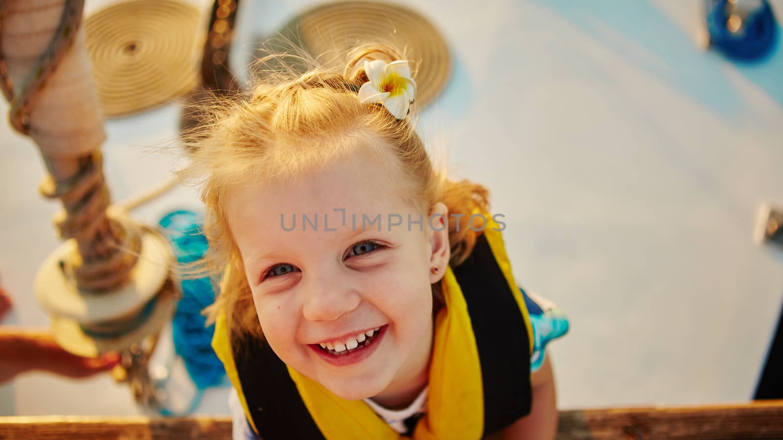 Little girl enjoying ride on yacht at sunset