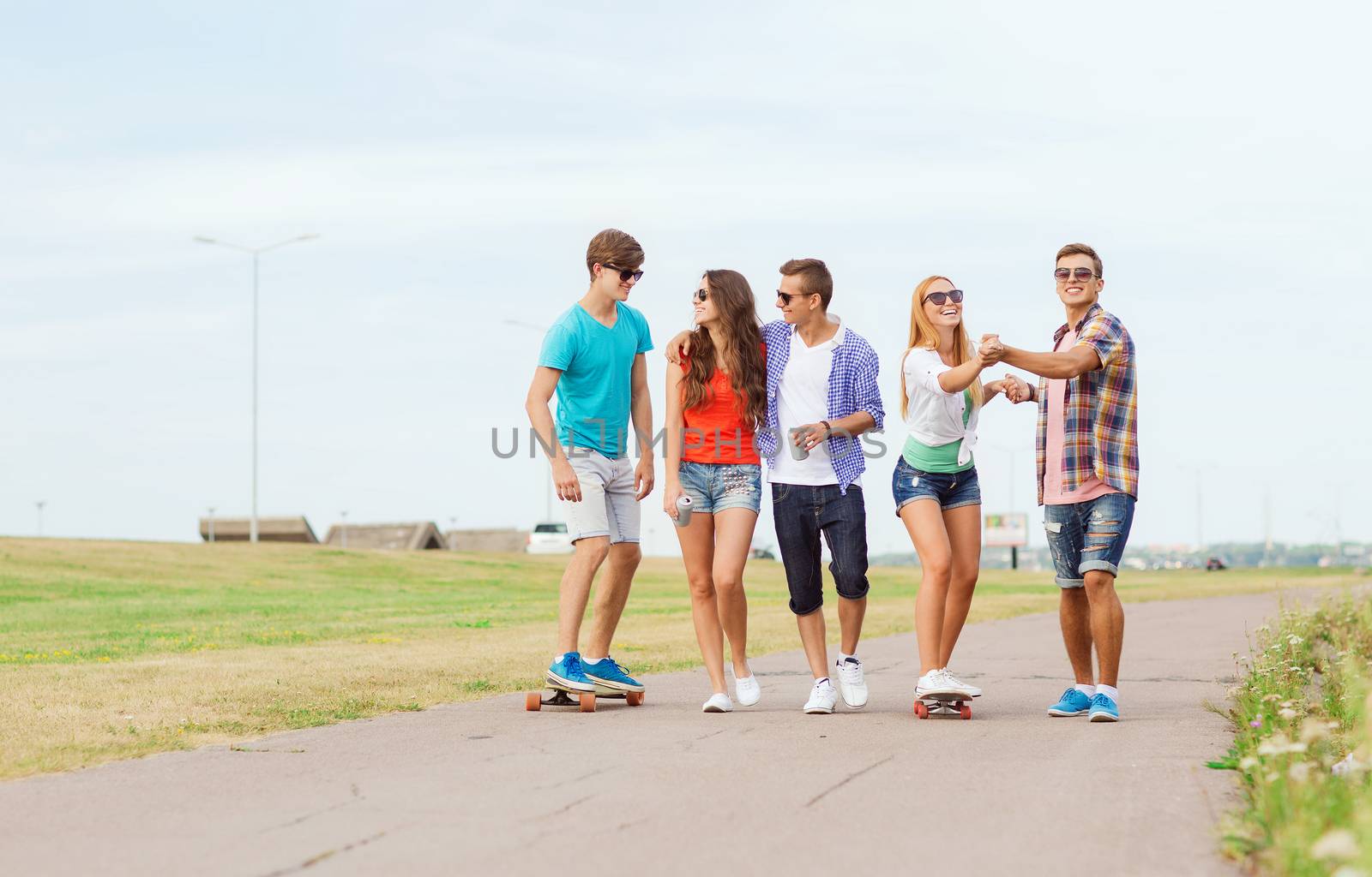group of smiling teenagers with skateboards by dolgachov