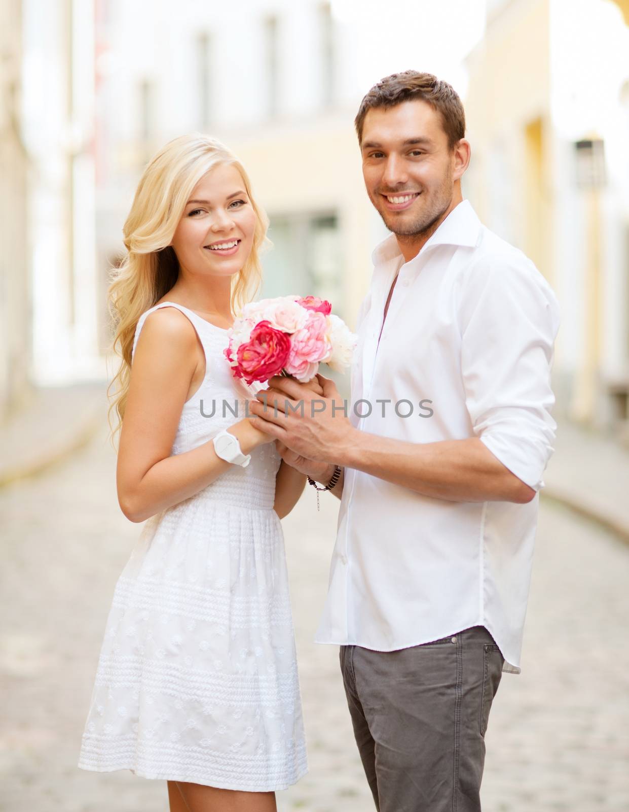 summer holidays and dating concept - couple with bouquet of flowers in the city