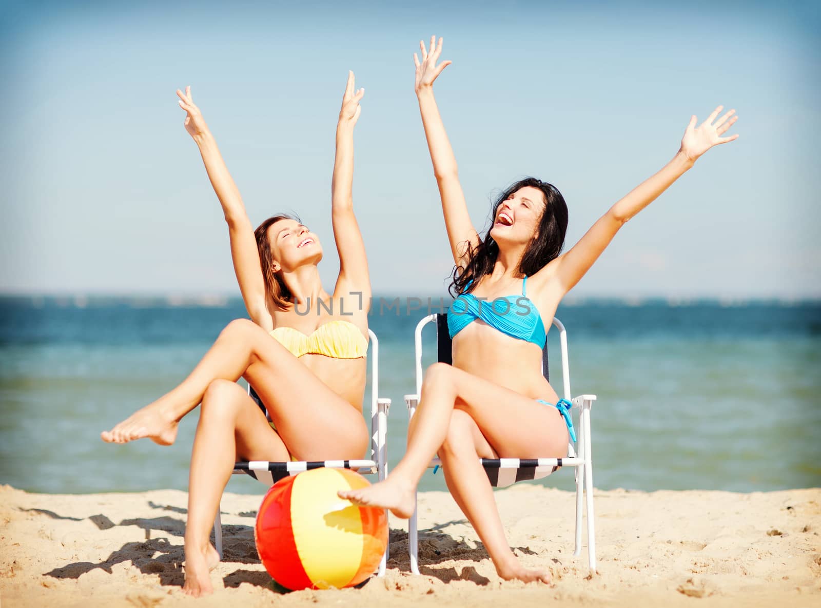 summer holidays and vacation - girls sunbathing on the beach chairs