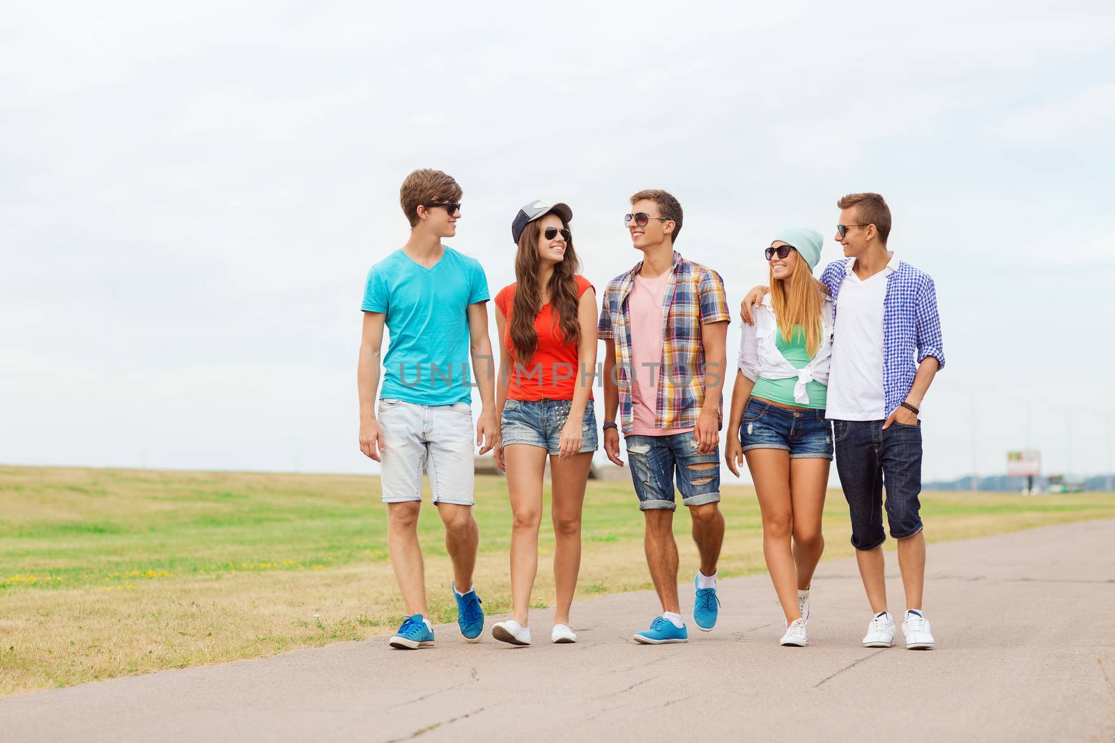 holidays, vacation, love and friendship concept - group of smiling teenagers walking outdoors